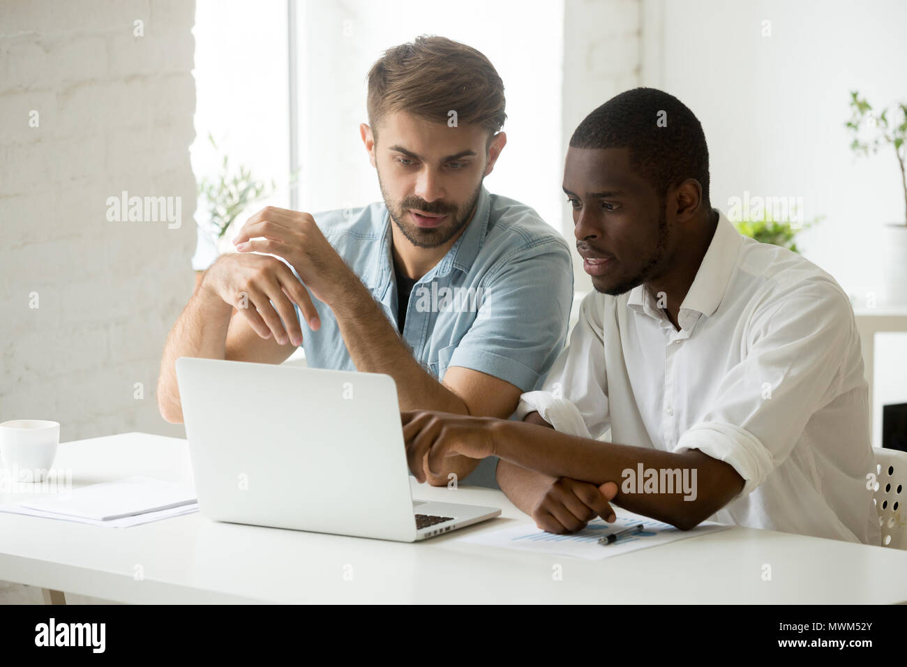 Colleagues discussing business issues, working at laptop Stock Photo