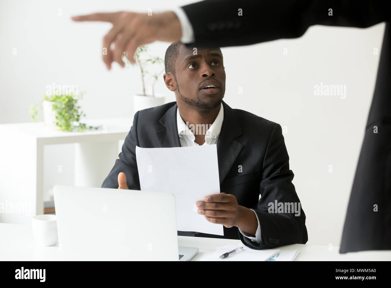 Frustrated African American worker being fired and asked to leav Stock Photo