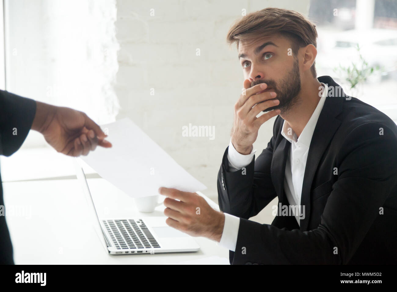 Shocked worker getting dismissal notice from black boss Stock Photo