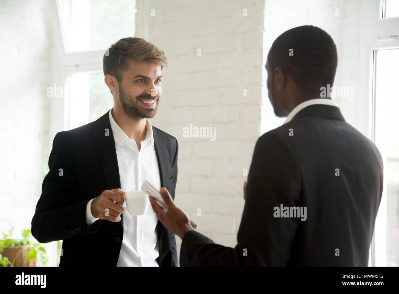 Multiethnic colleagues having business conversation during coffe Stock Photo