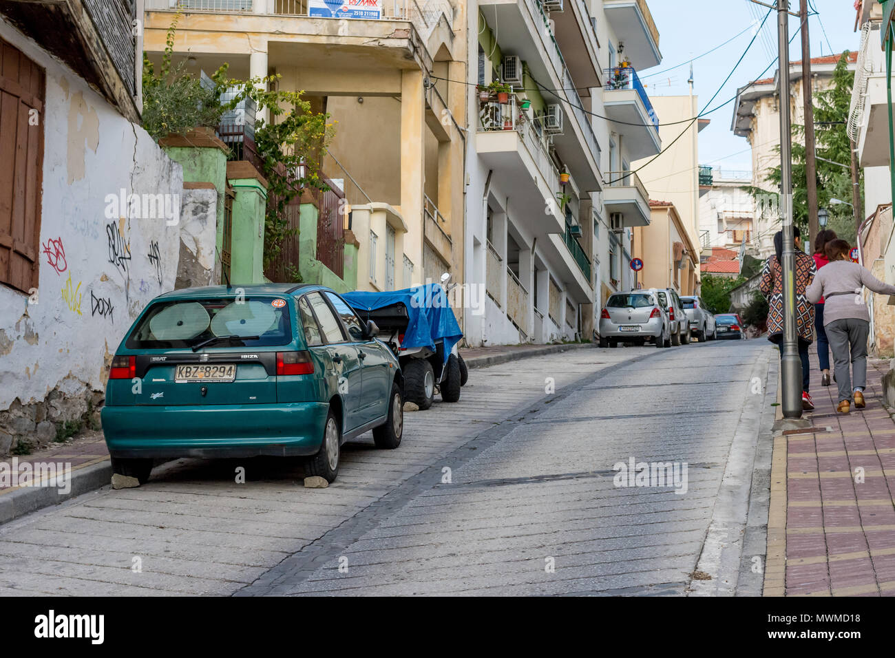Car parked on steep hill, with rocks rammed under the back wheels to