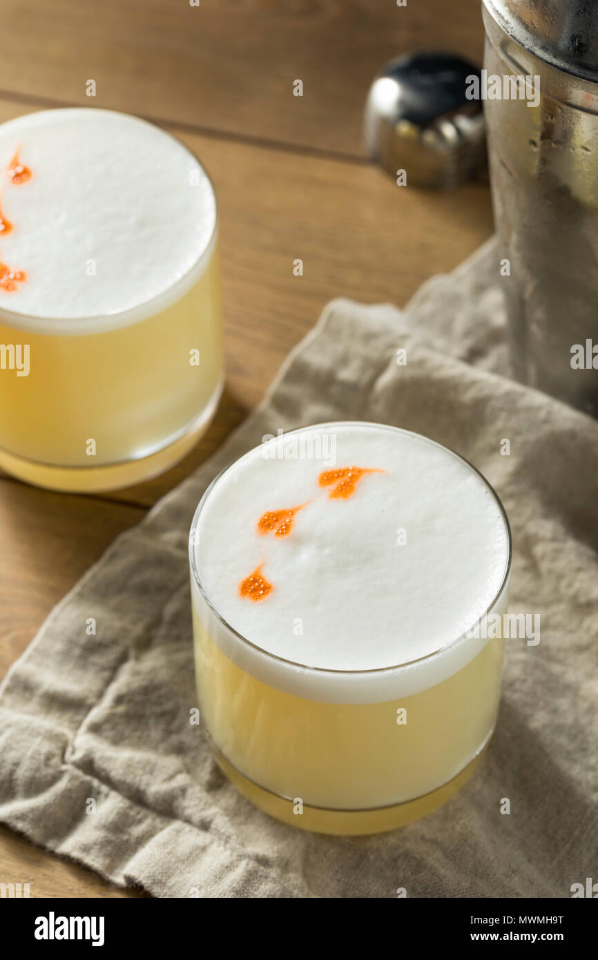 Homemade Pisco Sour Cocktail with Lime and Bitters Stock Photo