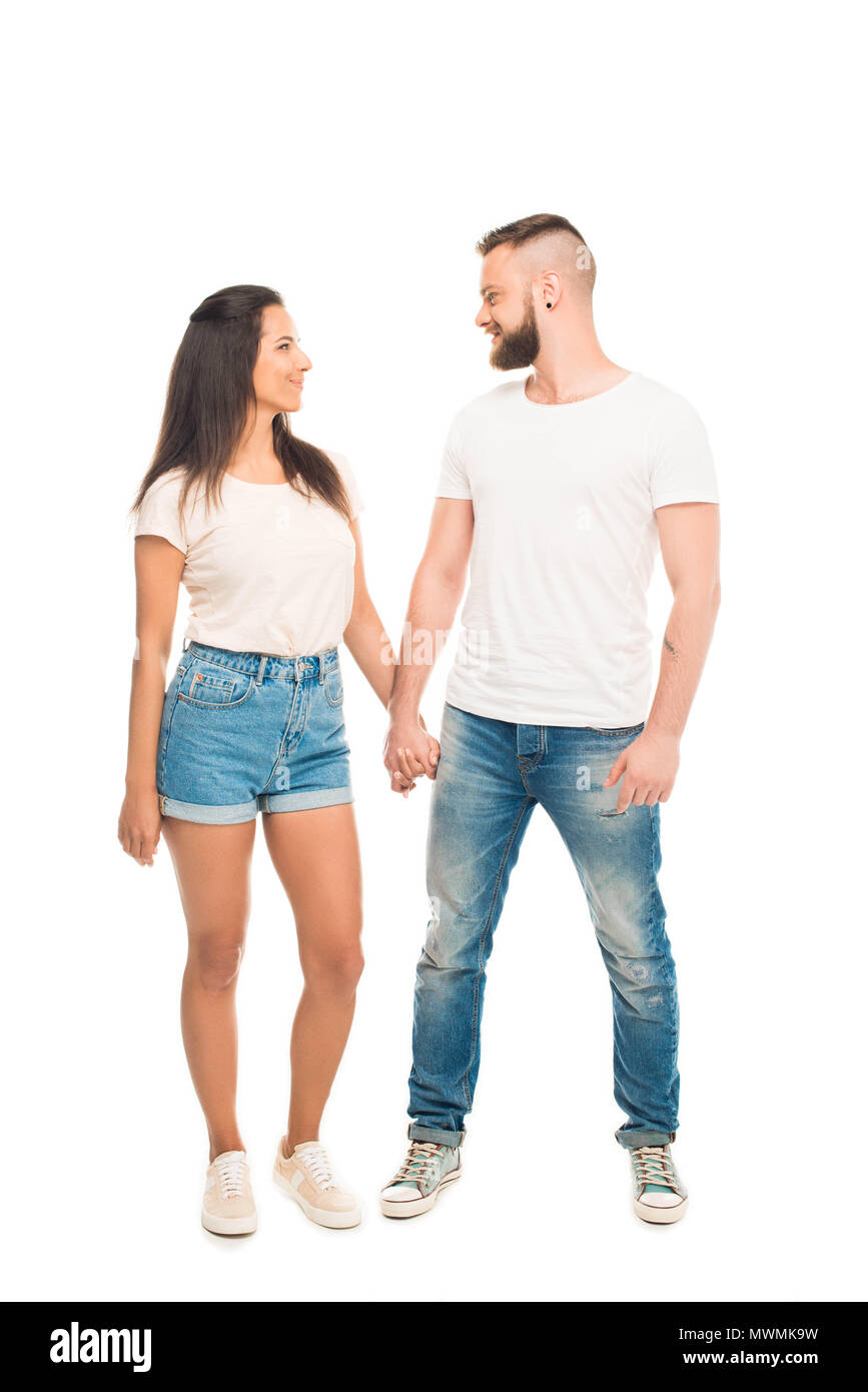'Full length portrait of young attractive couple holding hands ...