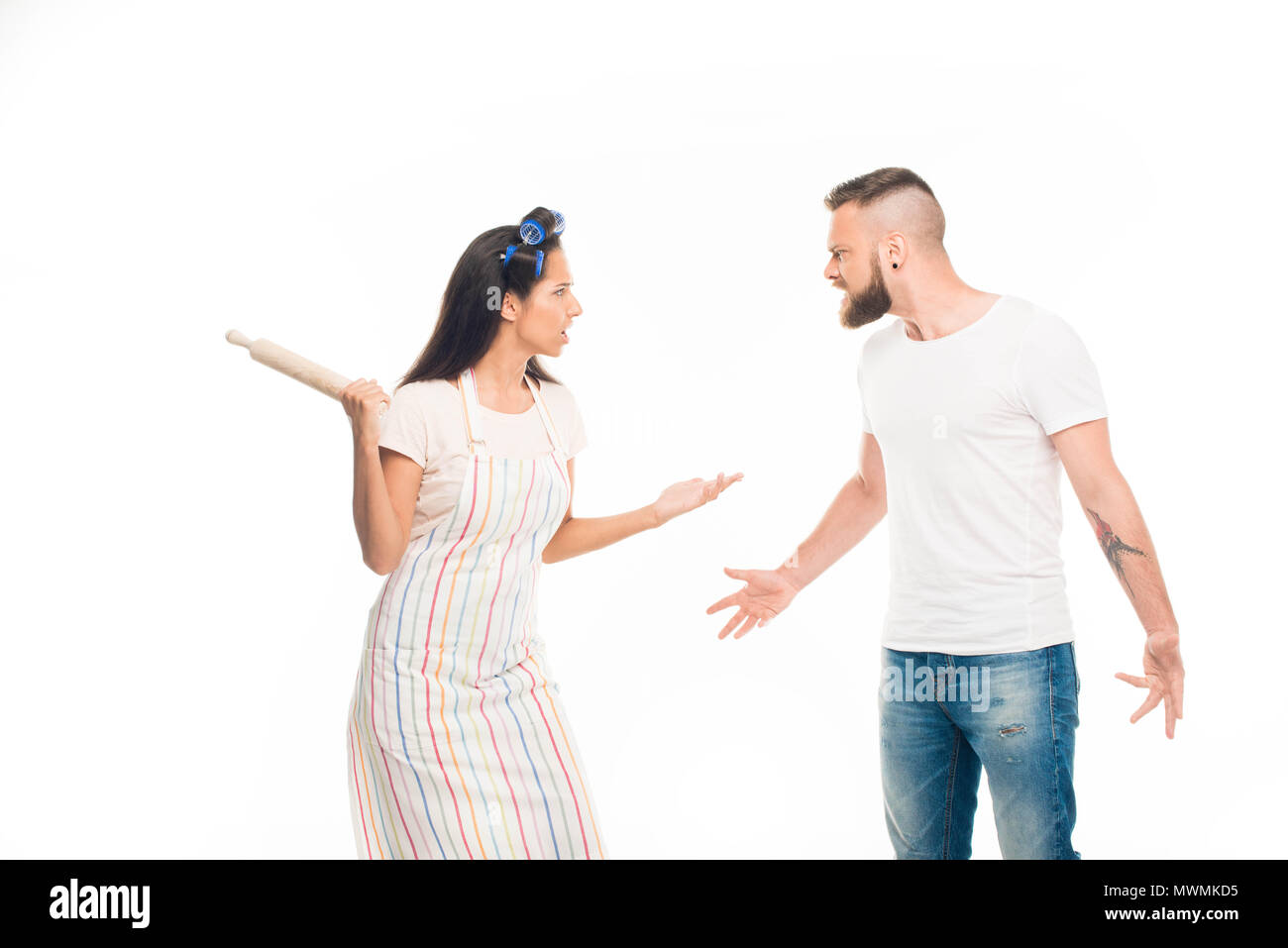 'Angry housewife with rolling pin having conflict with husband, isolated on white Stock Photo
