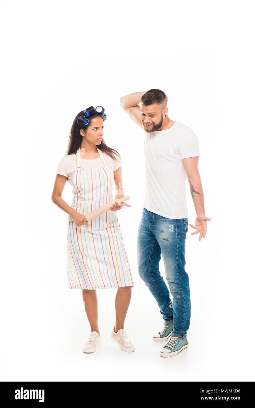 'Angry housewife with rolling pin having conflict with husband, isolated on white Stock Photo