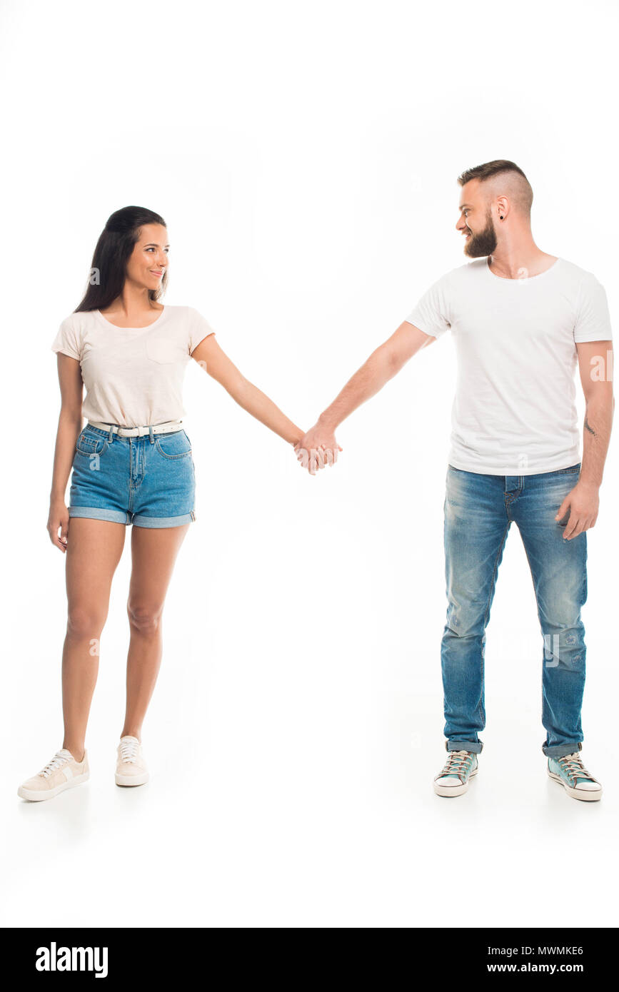 'Full length portrait of young attractive couple holding hands ...