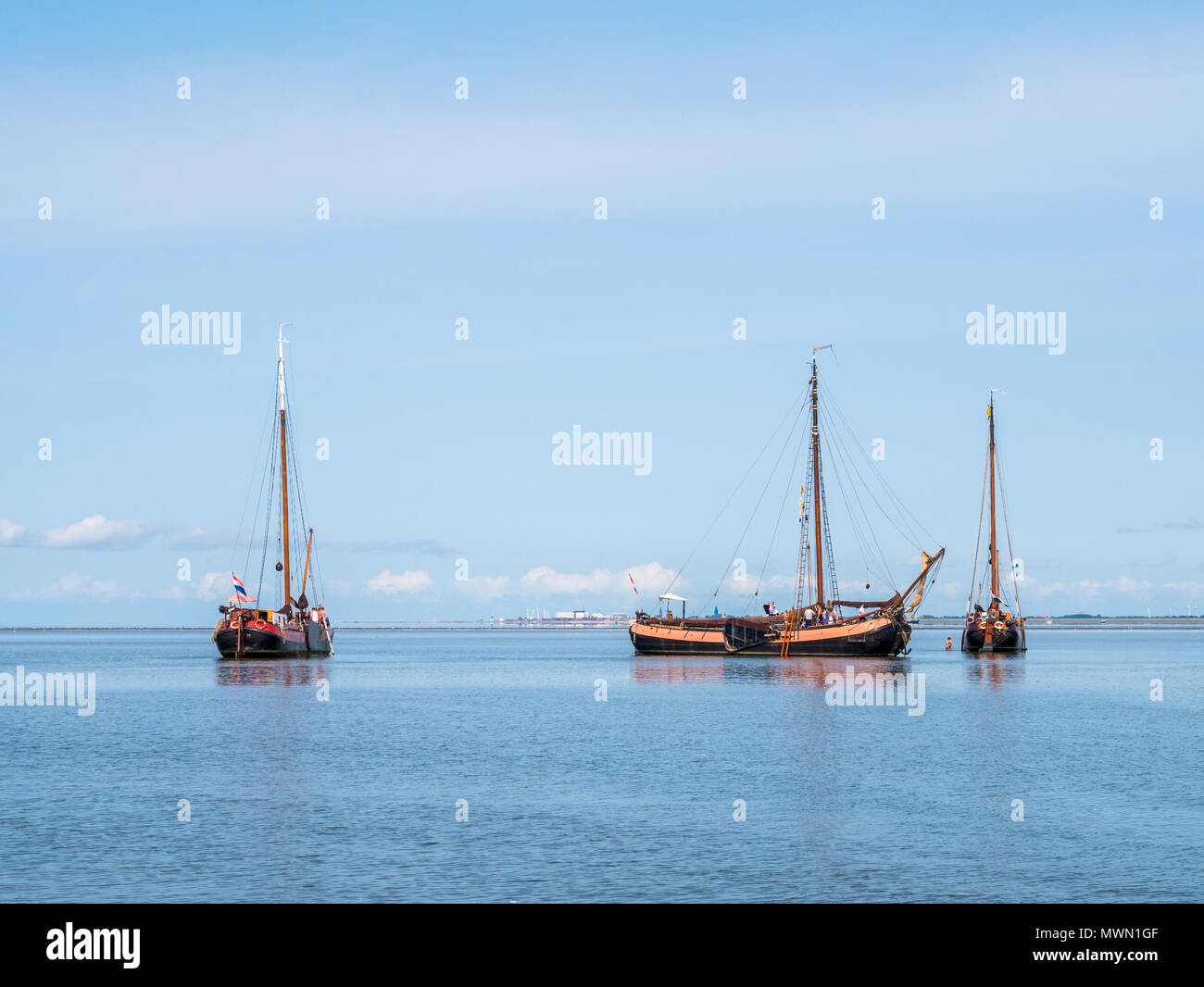 Flat-bottom sailing yachts dried out at low tide on Waddensea near Harlingen, Friesland, Netherlands Stock Photo