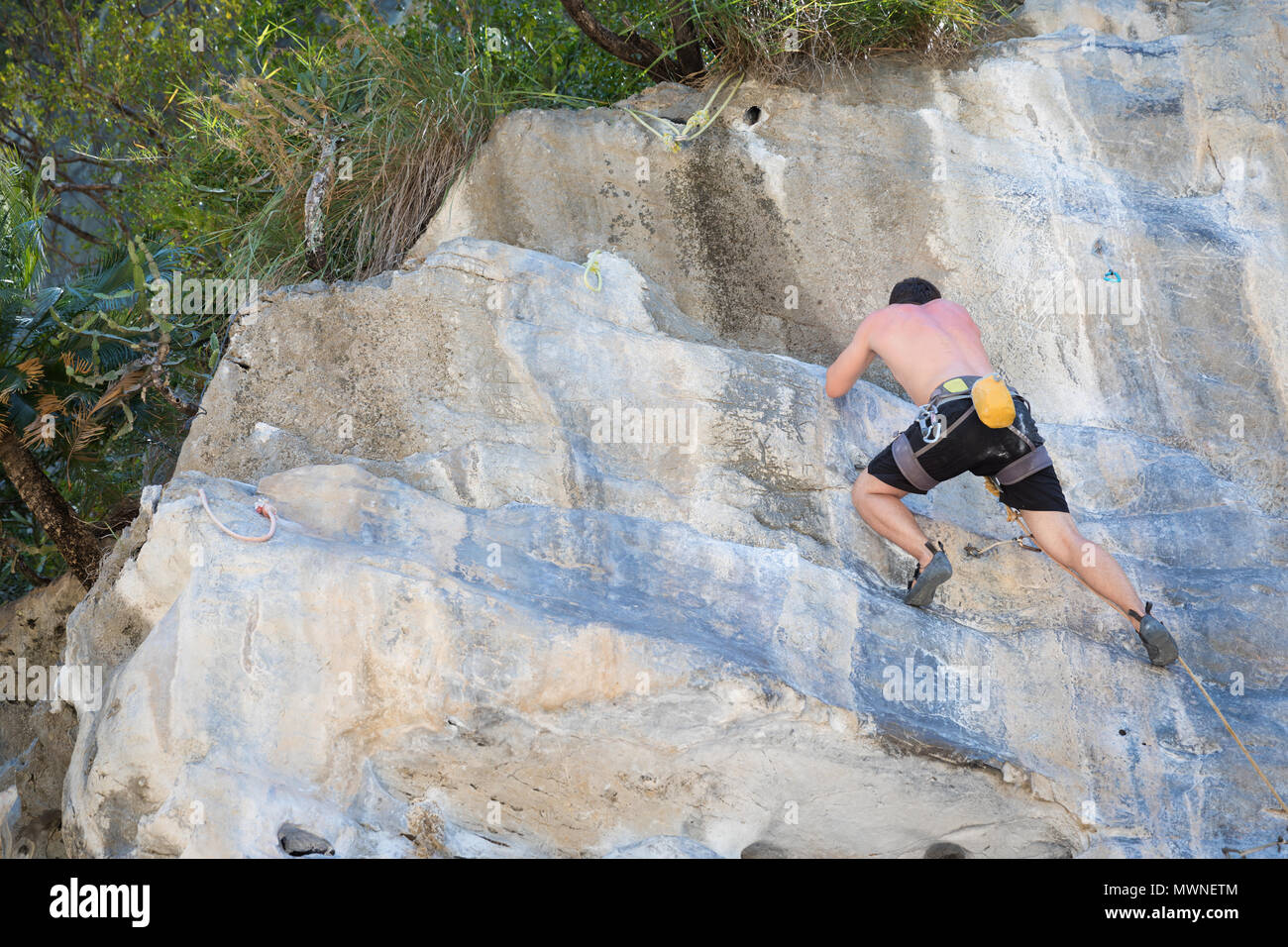 Young man rock climbing on white mountain  Stock Photo