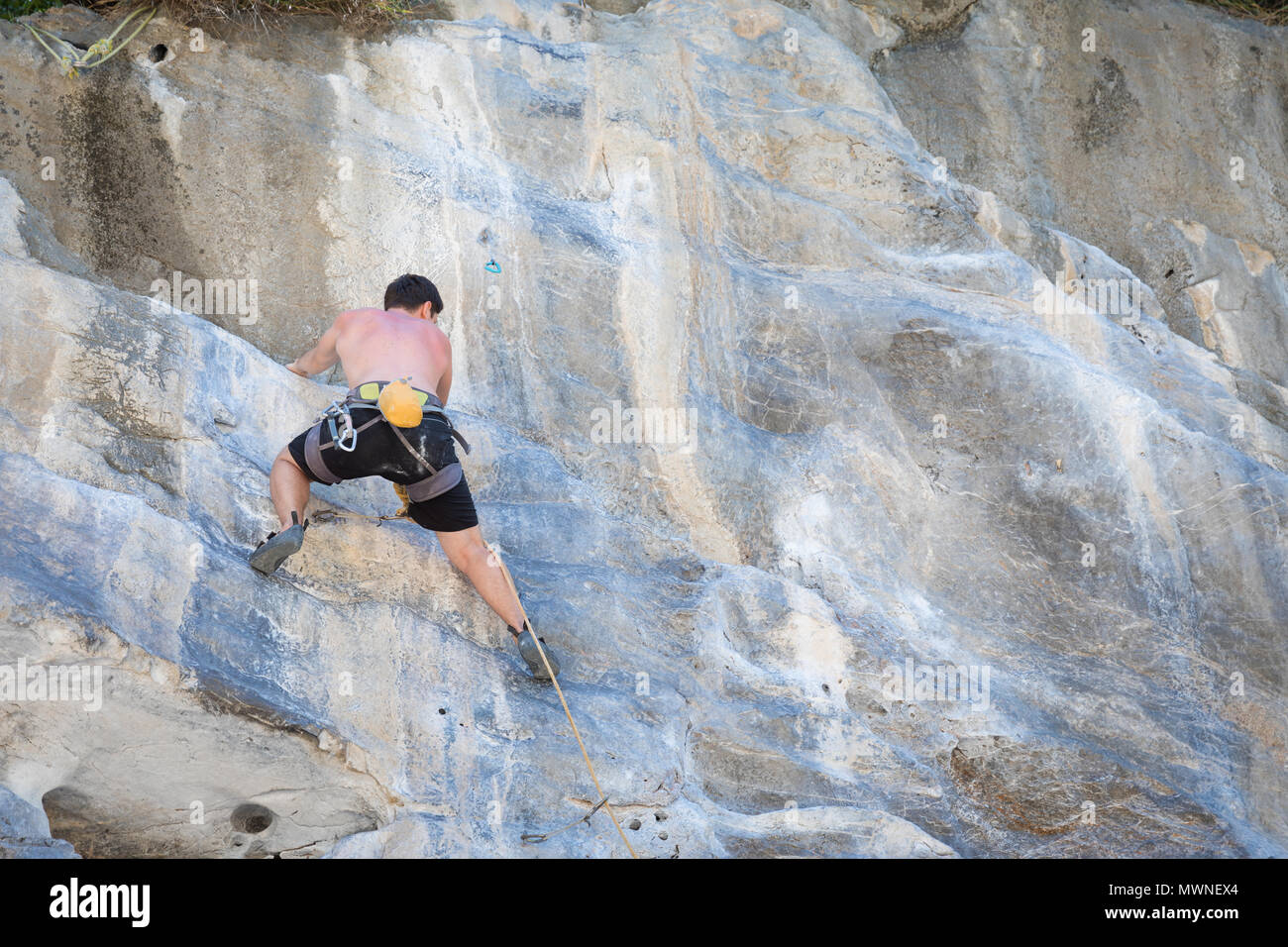 Young man rock climbing on white mountain  Stock Photo