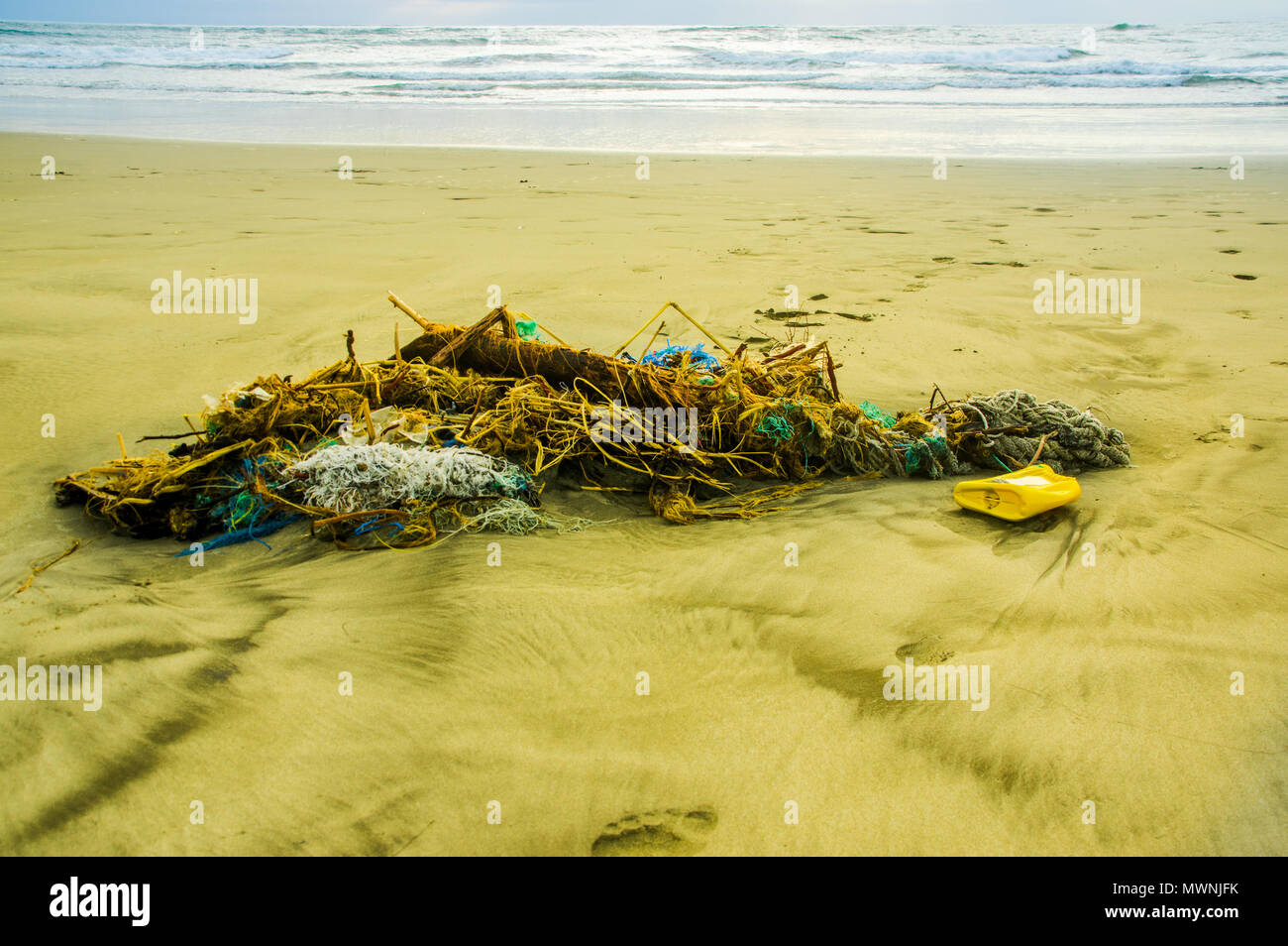Outdoor view of fishing net and ropes garbage in the beach, every day, waste accumulates on the beach of Atlantic west coast, they arrive from ocean currents effect Stock Photo