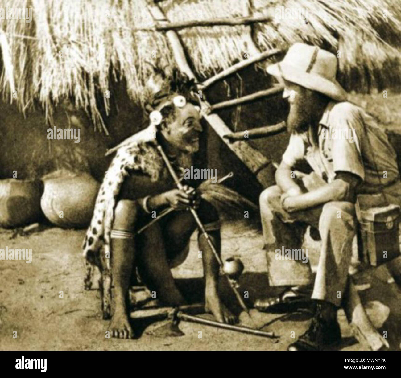 . Talking with a pygmy shaman in Africa. The photo probably taken by Kazimierz Nowak (1897-1937, the author is on the photo; taken probably by a self-timer) during his trip through Africa - a Polish traveller, correspondent and photographer. Probably the first man in the world who crossed Africa alone from the North to the South and from the South to the North (from 1931 to 1936; on foot, by bicycle and canoe). circa about 1931-36. probably Kazimierz Nowak or an unknown author 507 Pygmy shaman Stock Photo