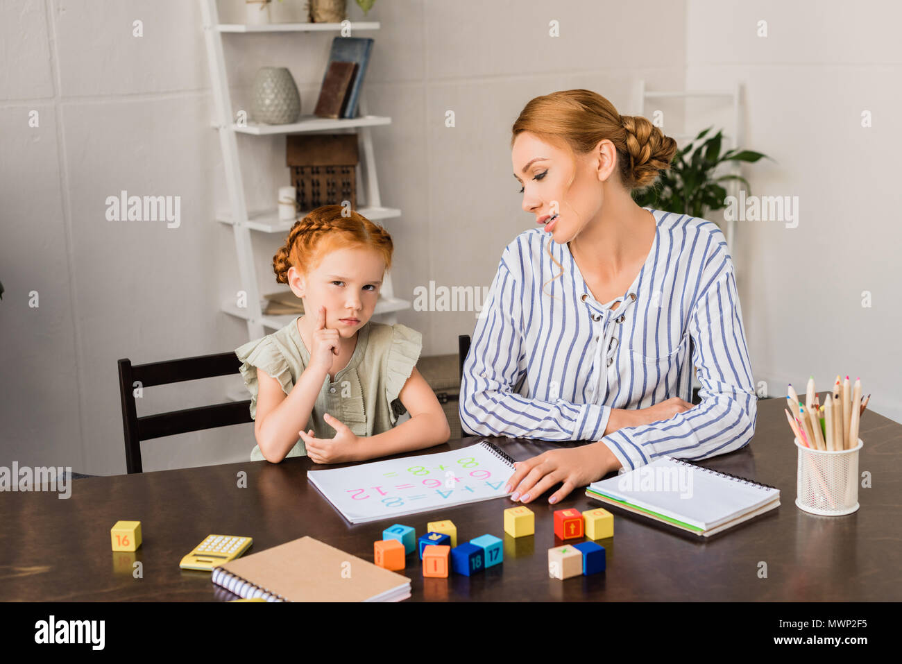 Mother and exhausted sad daughter learning math at home stock photo alamy