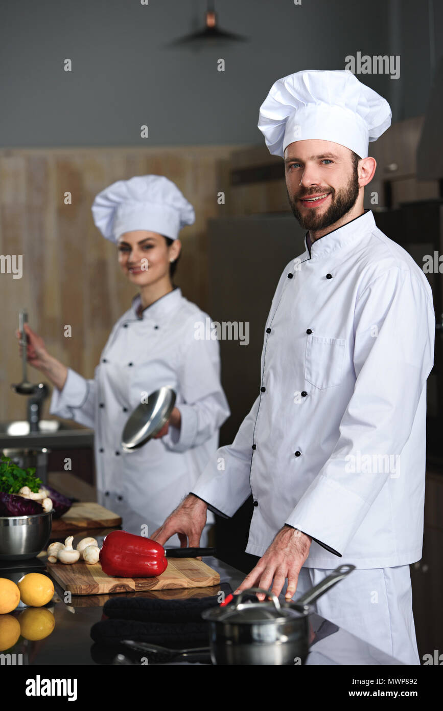 Professional chefs man and woman cooking in restaurant kitchen Stock Photo