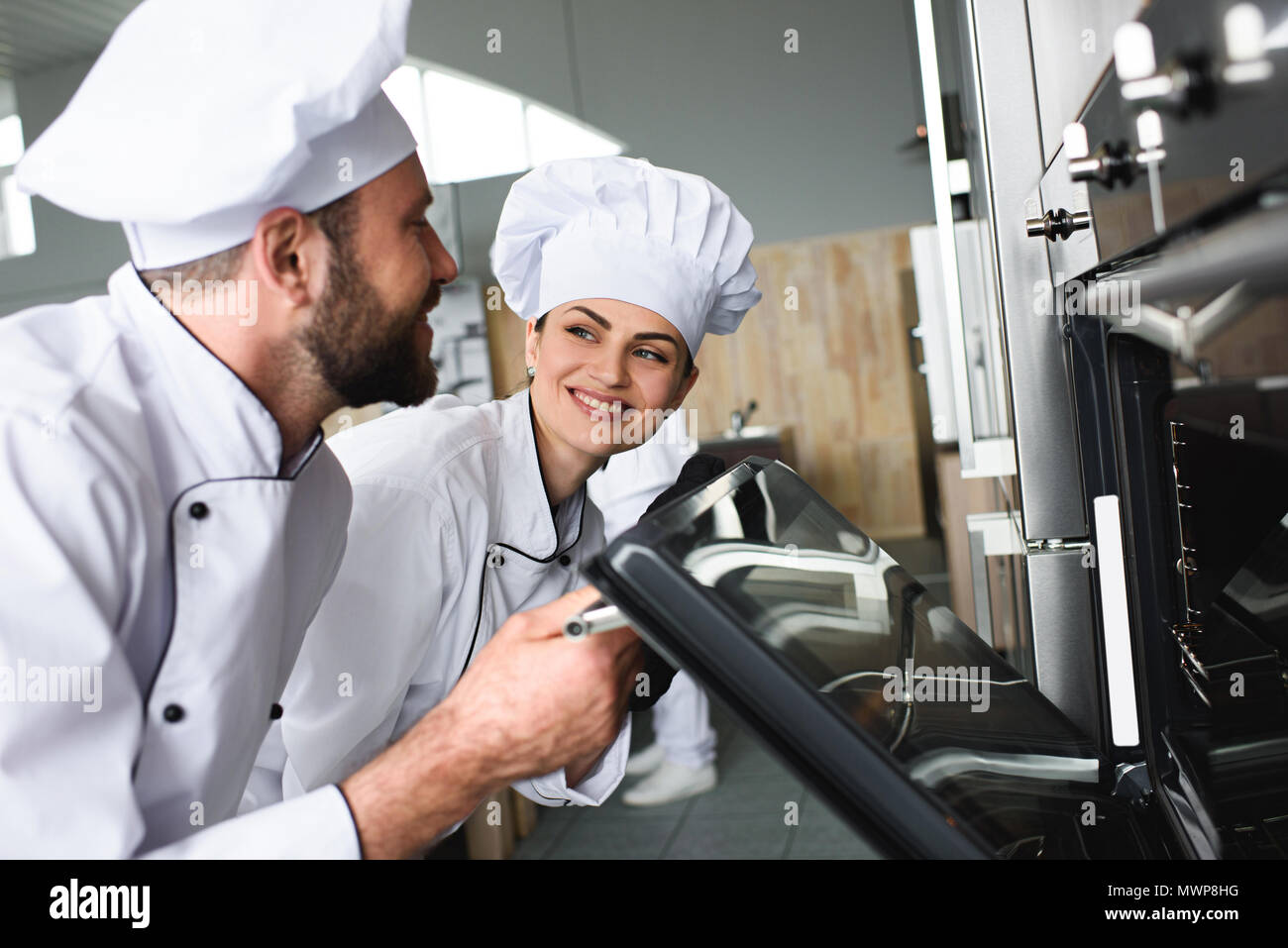 Professional chefs checking baling oven in kitchen Stock Photo