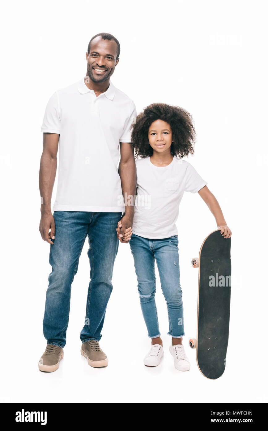 happy african american father and cute little daughter with skateboard ...
