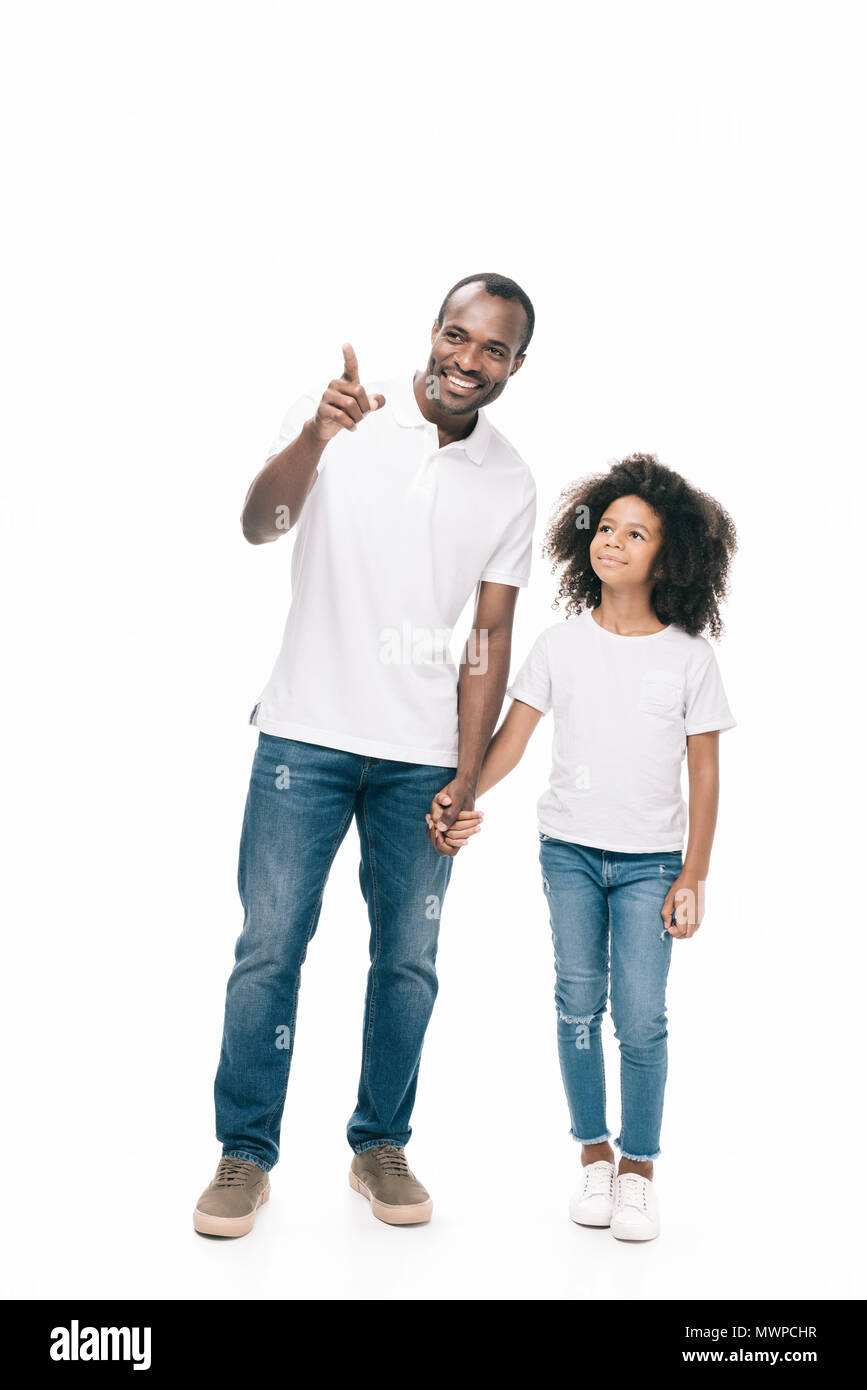 happy african american father and daughter holding hands while standing ...