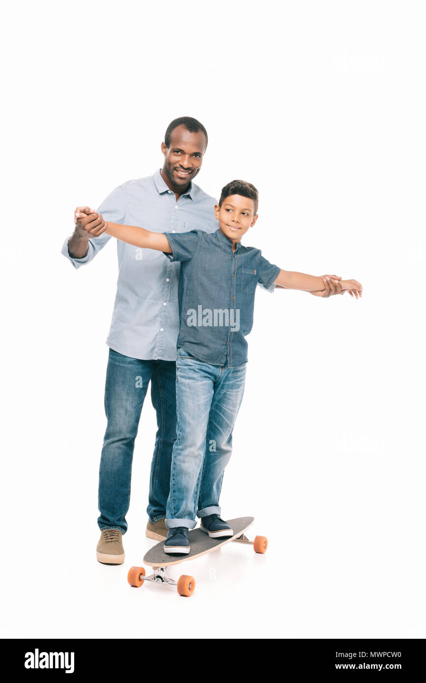 happy african american father holding hands of smiling son standing on ...