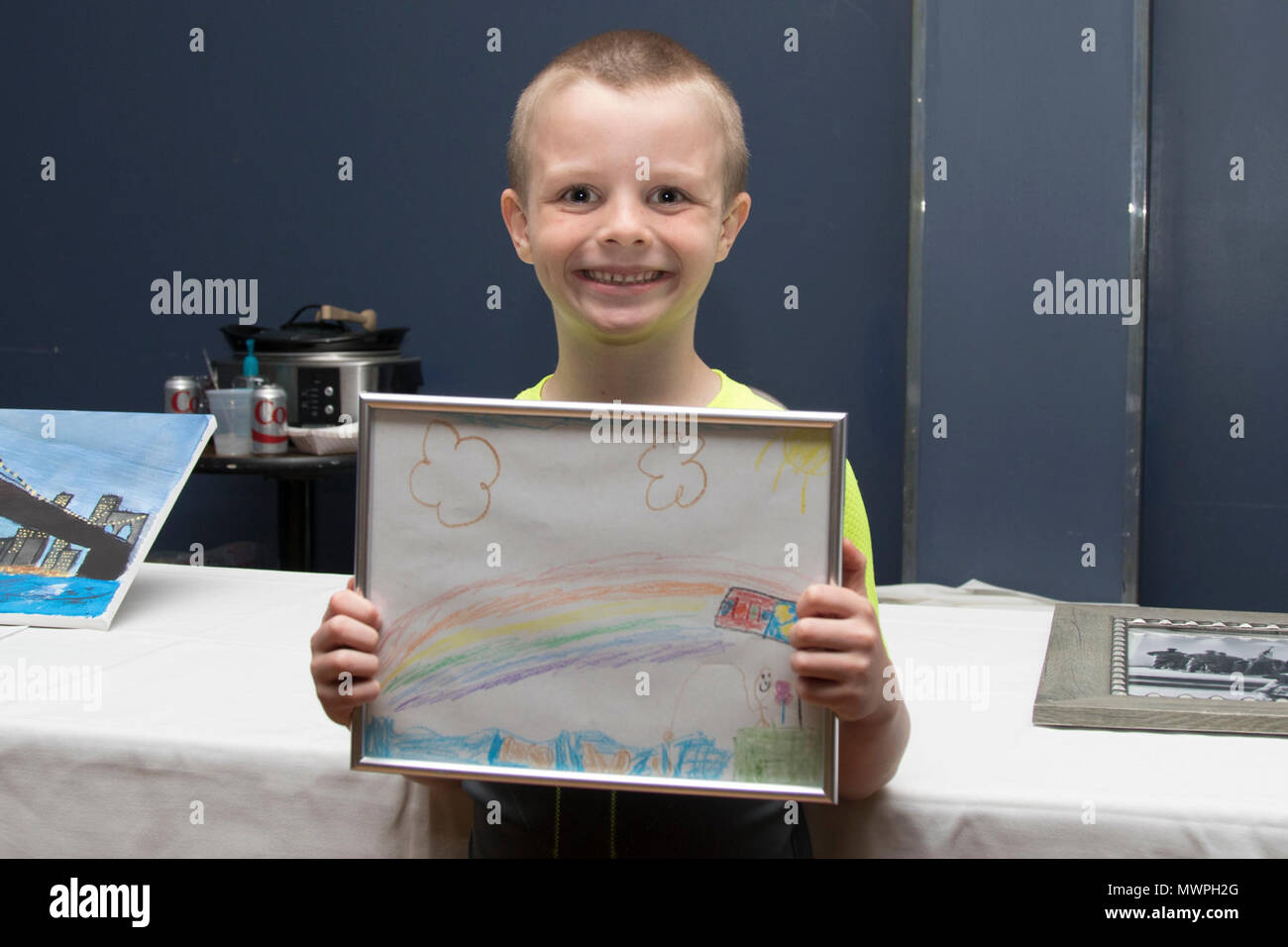 Young artist Gavin proudly displays his artwork donated for the
