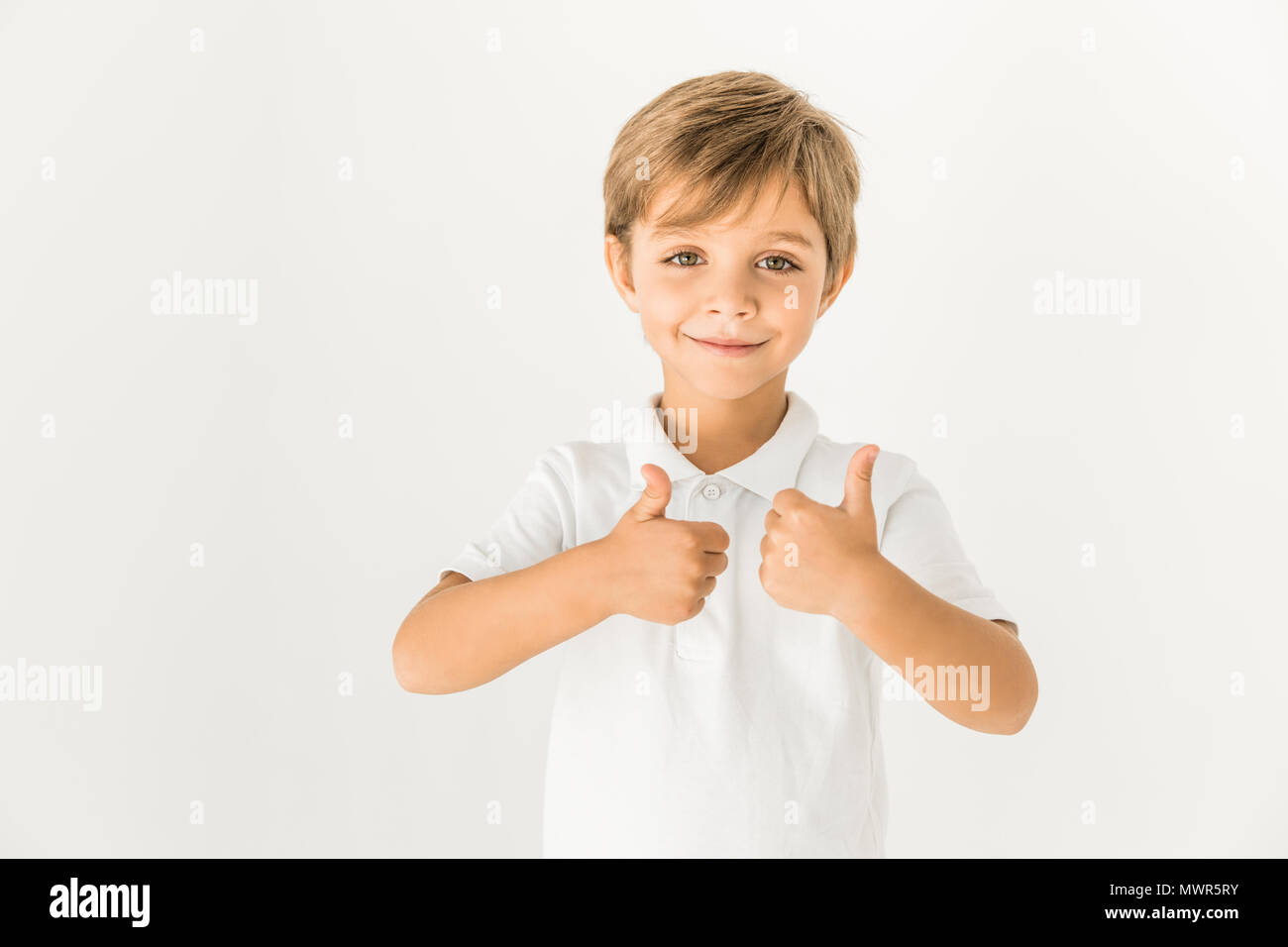 cute little boy showing thumbs up and smiling at camera isolated on ...