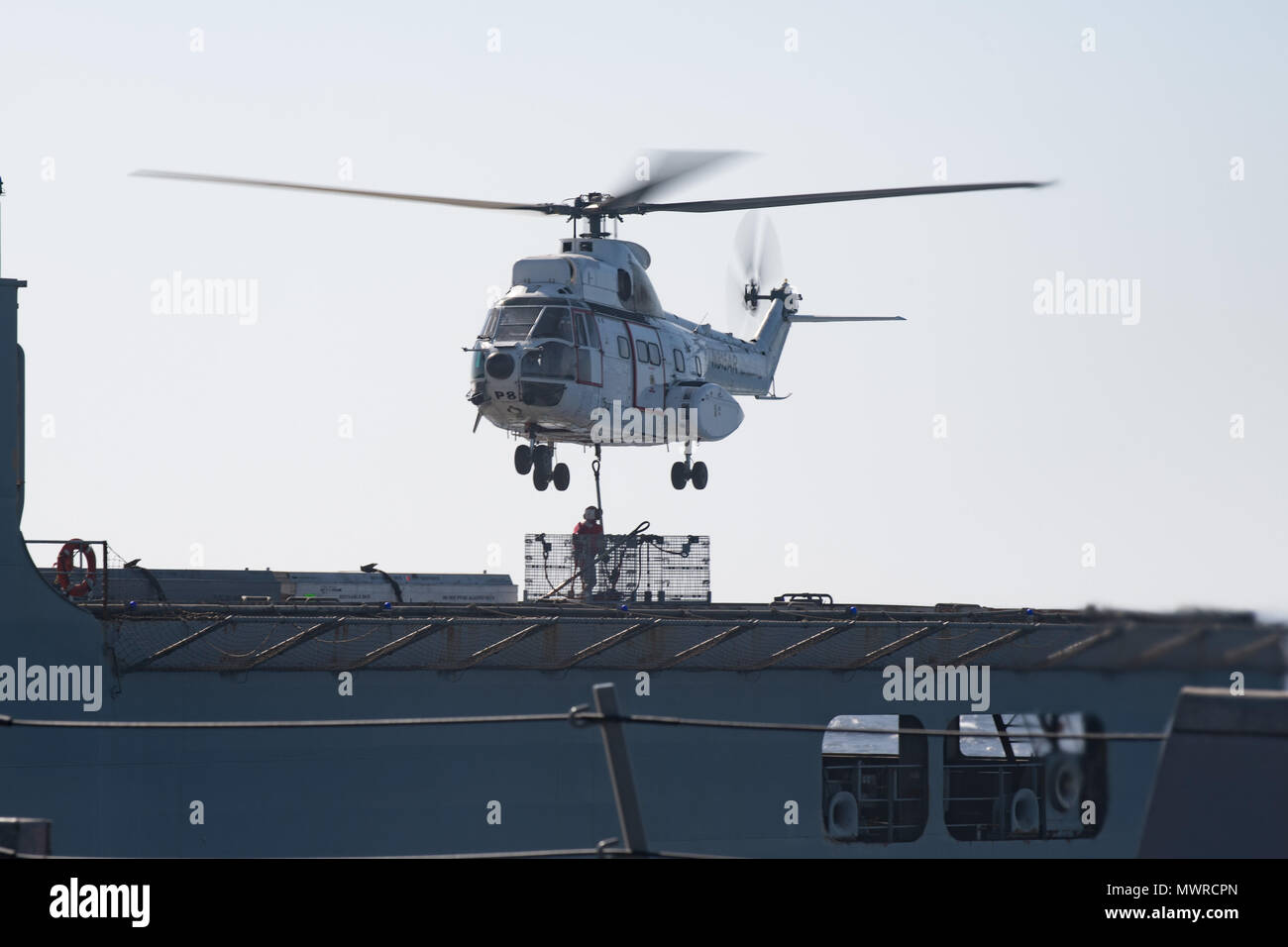 180516-N-AV754-0090 U.S. 5TH FLEET AREA OF OPERATIONS (May 16, 2018) A Eurocopter AS332 Super Puma helicopter picks up cargo from the dry cargo and ammunition ship USNS Amelia Earhart (T-AKE 6) during a replenishment-at-sea with the Arleigh Burke-class guided-missile destroyer USS Winston S. Churchill (DDG 81). Winston S. Churchill is deployed to the U.S. 5th Fleet area of operations in support of maritime security operations to reassure allies and partners and preserve the freedom of navigation and the free flow of commerce in the region. (U.S. Navy photo by Mass Communication Specialist 3rd  Stock Photo