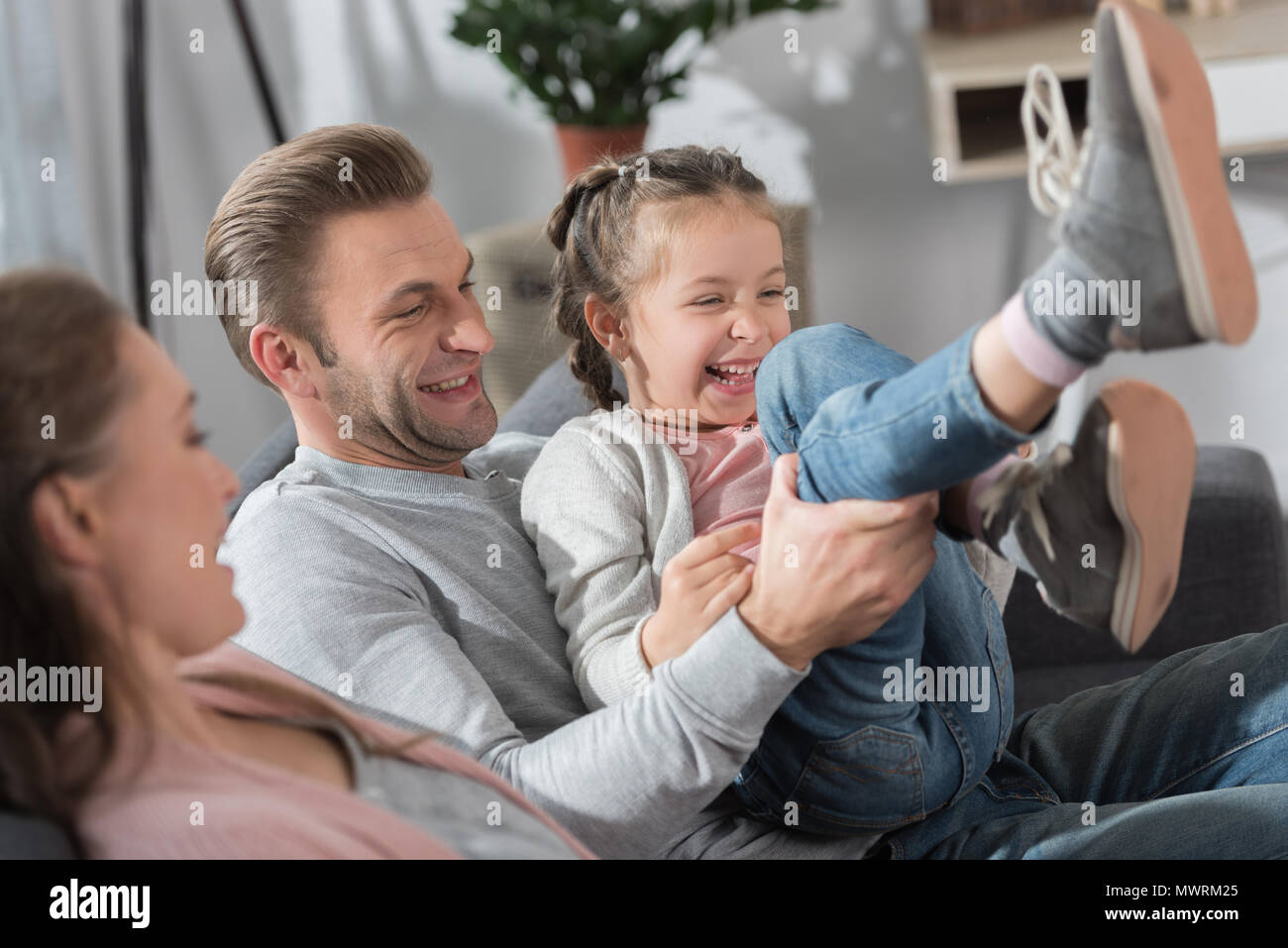 Father and mother having fun with daughter Stock Photo - Alamy