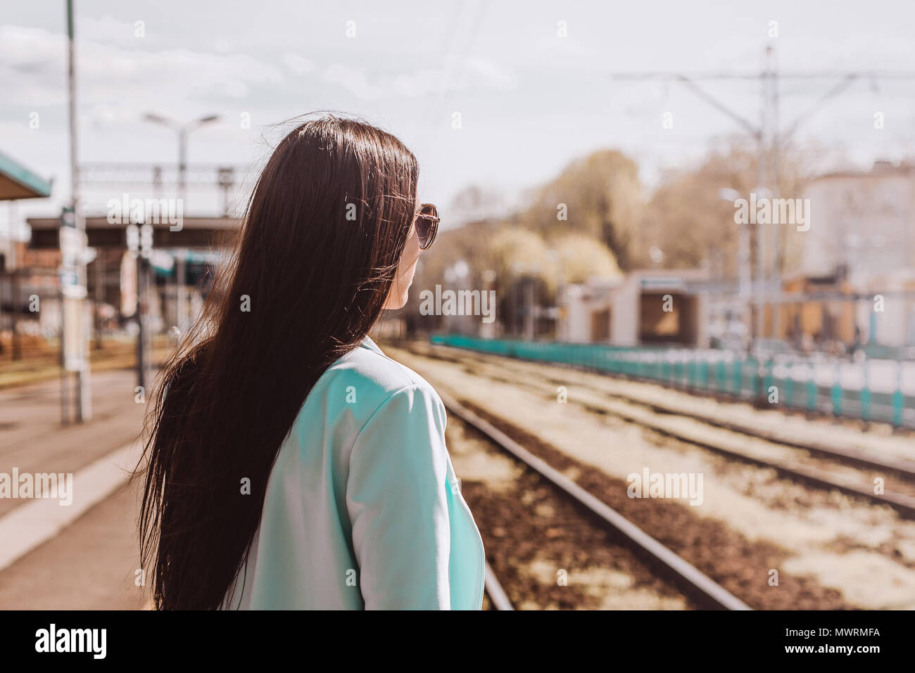 Portrait of a woman looking out for an oncoming train. Return of a ...