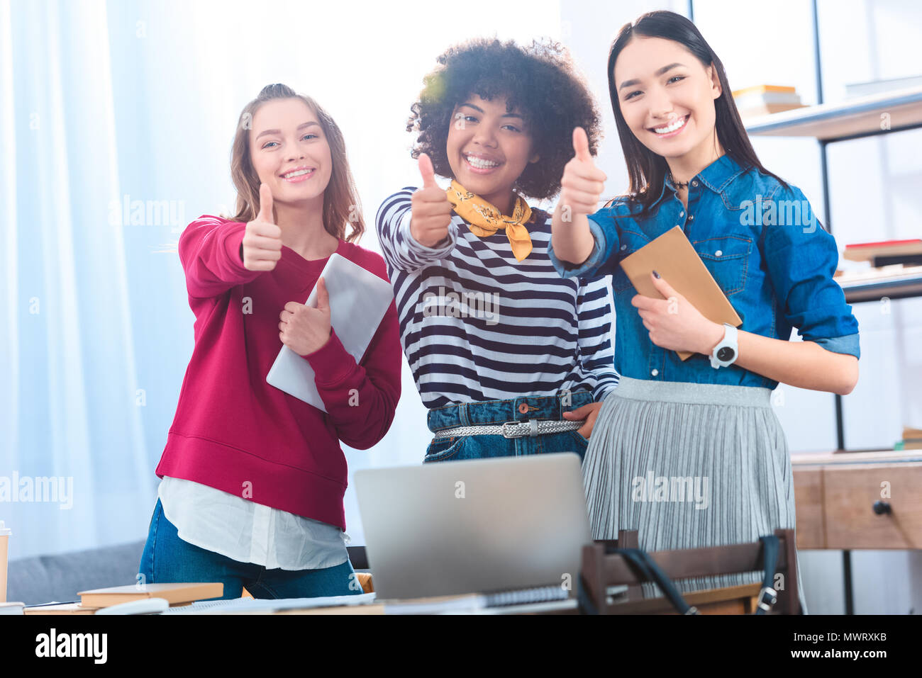 portrait of smiling multiethnic students showing thumbs up Stock Photo ...