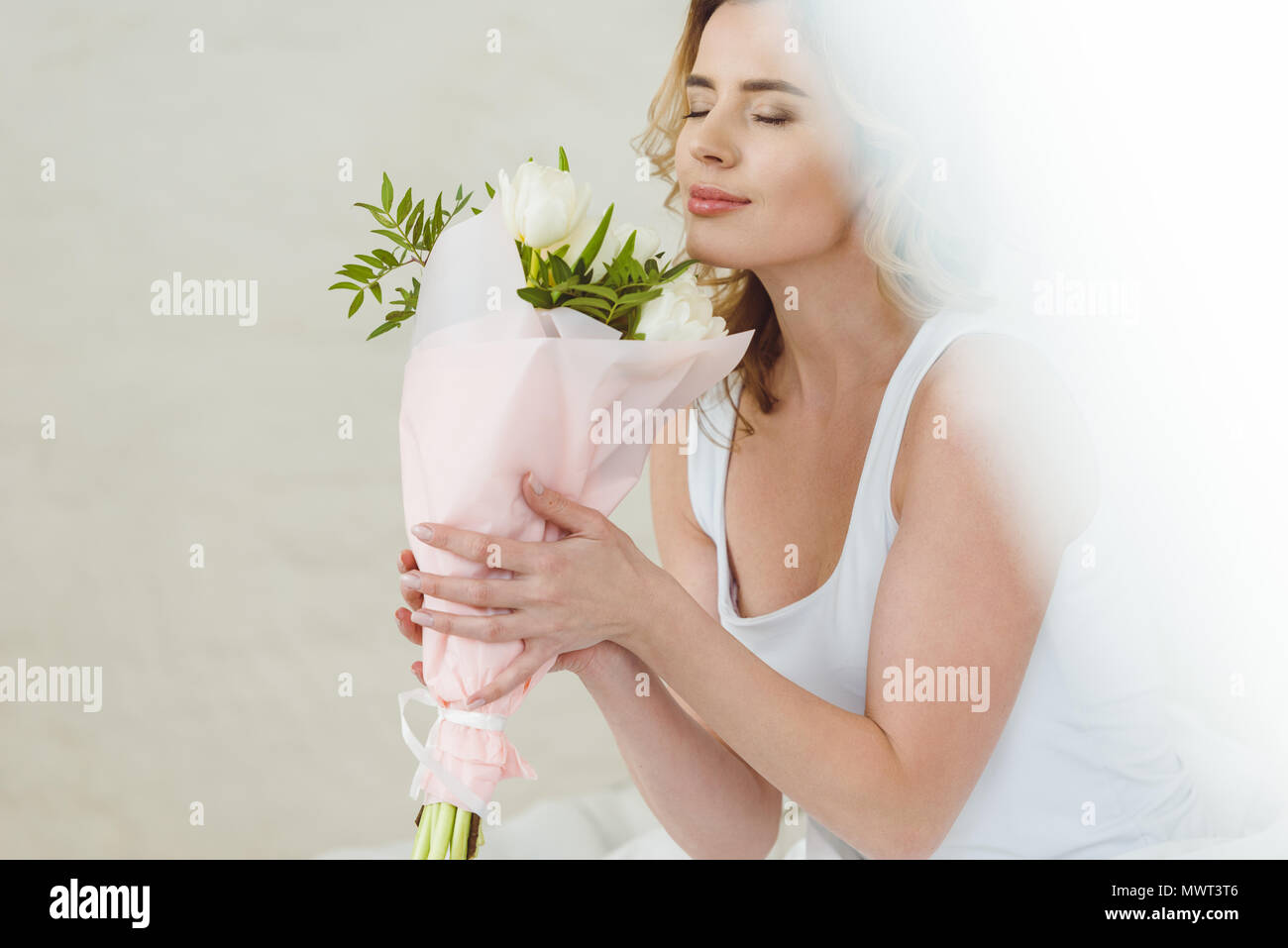 beautiful woman sniffing bouquet of flowers for international womens day Stock Photo