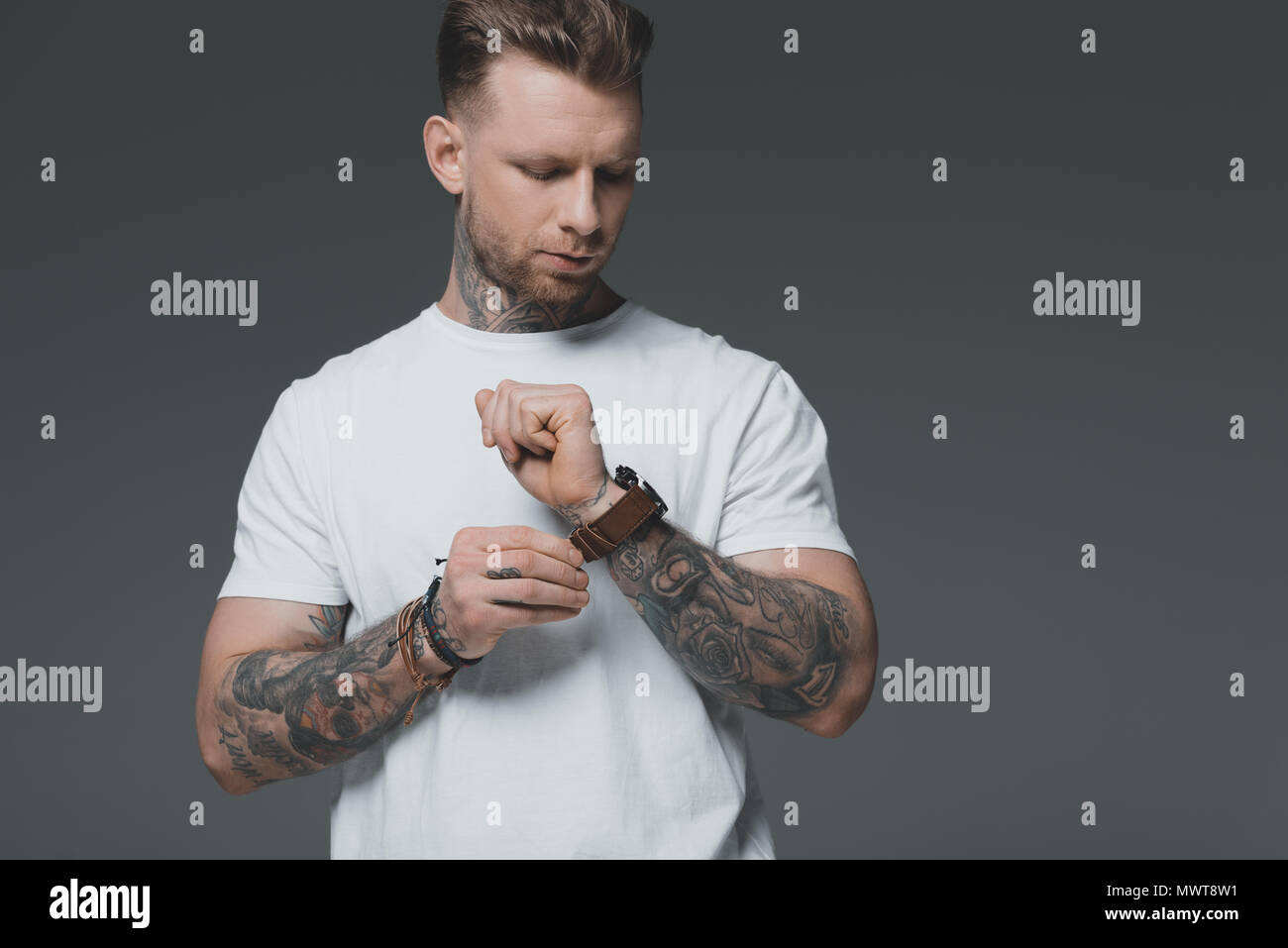 handsome stylish young tattooed man in white t-shirt wearing wristwatch isolated on grey Stock Photo - Alamy