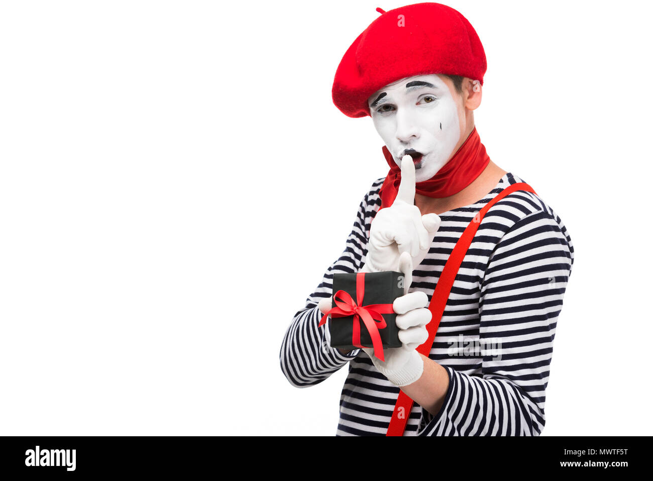 mime holding present box and showing silence gesture isolated on white Stock Photo