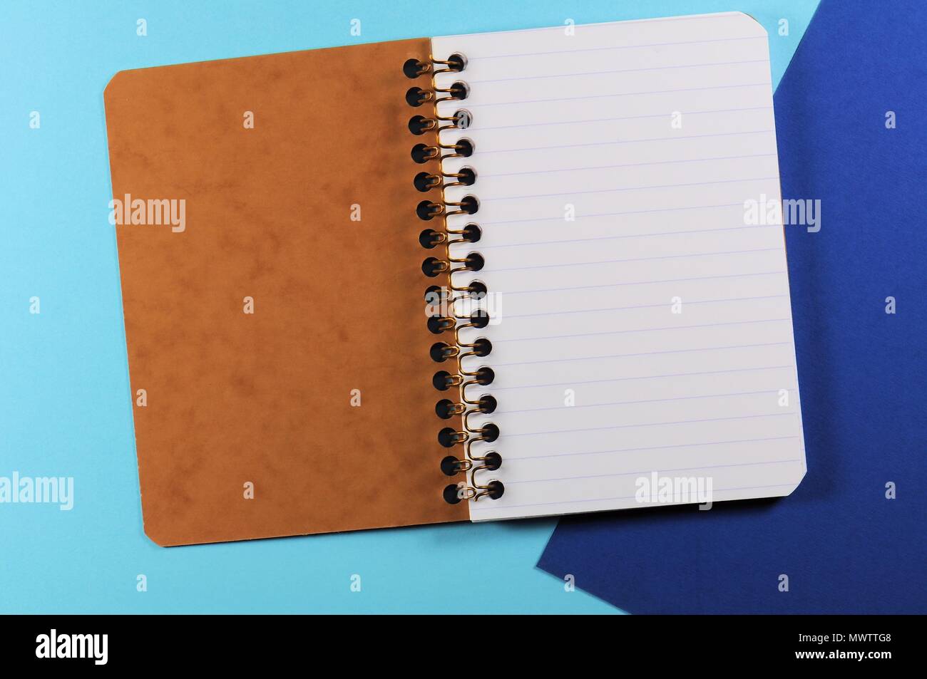 Empty open striped notebook close up on blue background Stock Photo