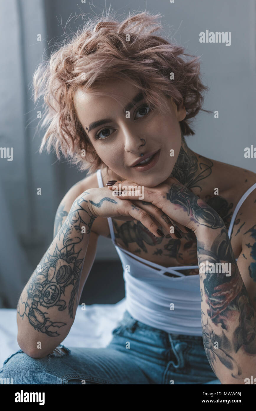 portrait of beautiful tattooed girl with pink hair in bedroom Stock Photo -  Alamy