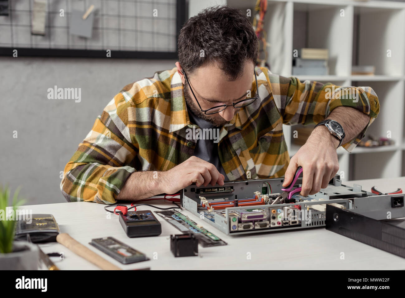 repairman using tongs while fixing broken pc Stock Photo