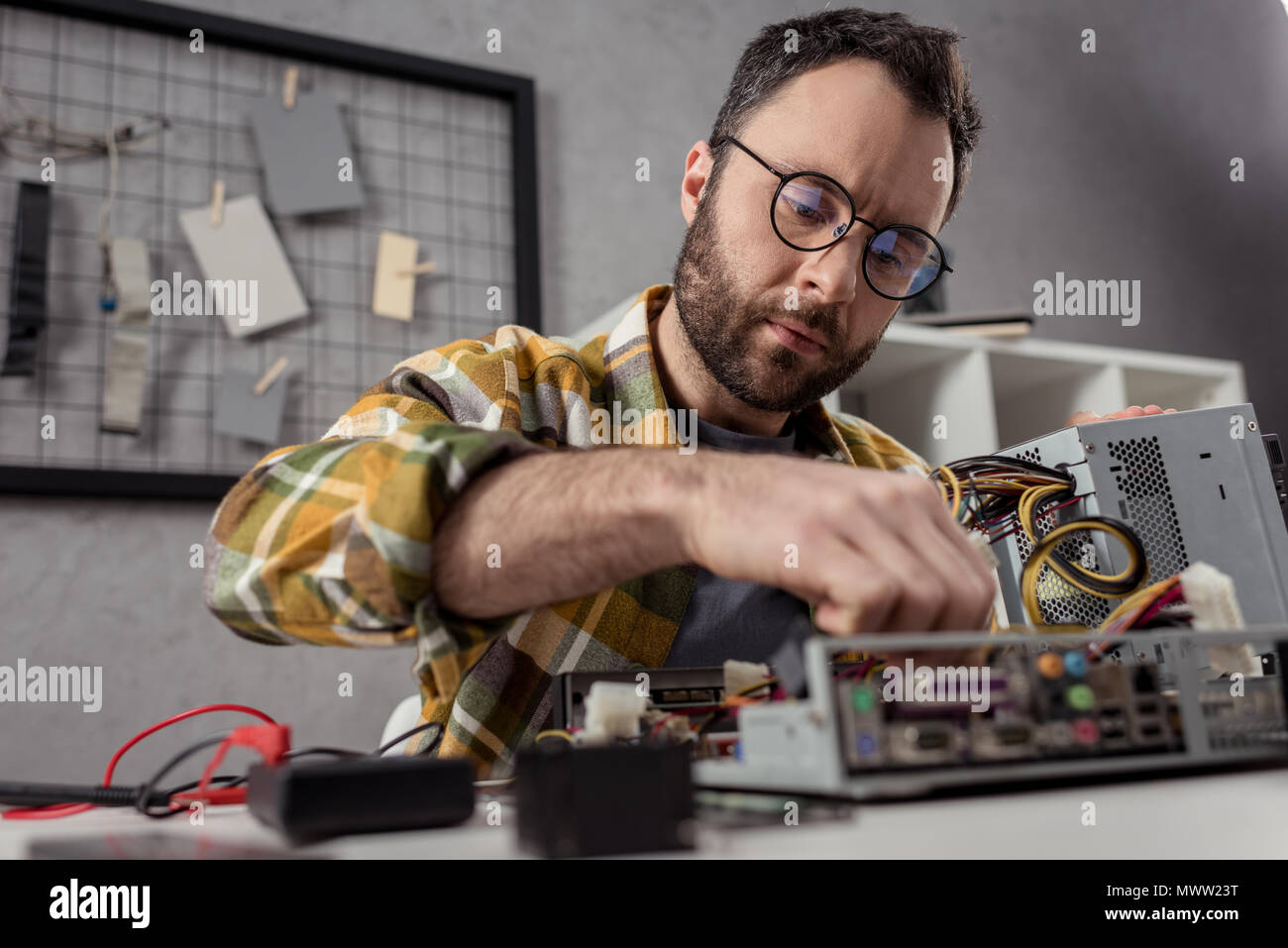 repairman in glasses fixing broken pc Stock Photo