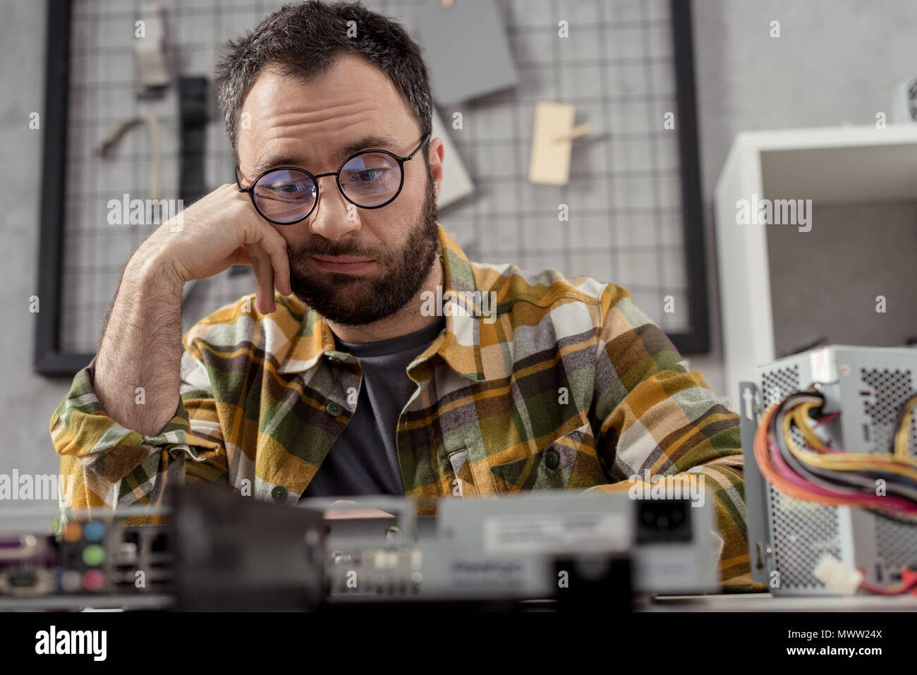 discouraged repairman looking at broken pc Stock Photo