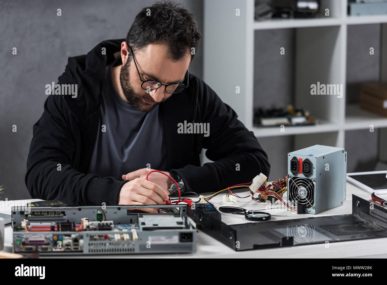 man using multimeter while fixing broken pc Stock Photo