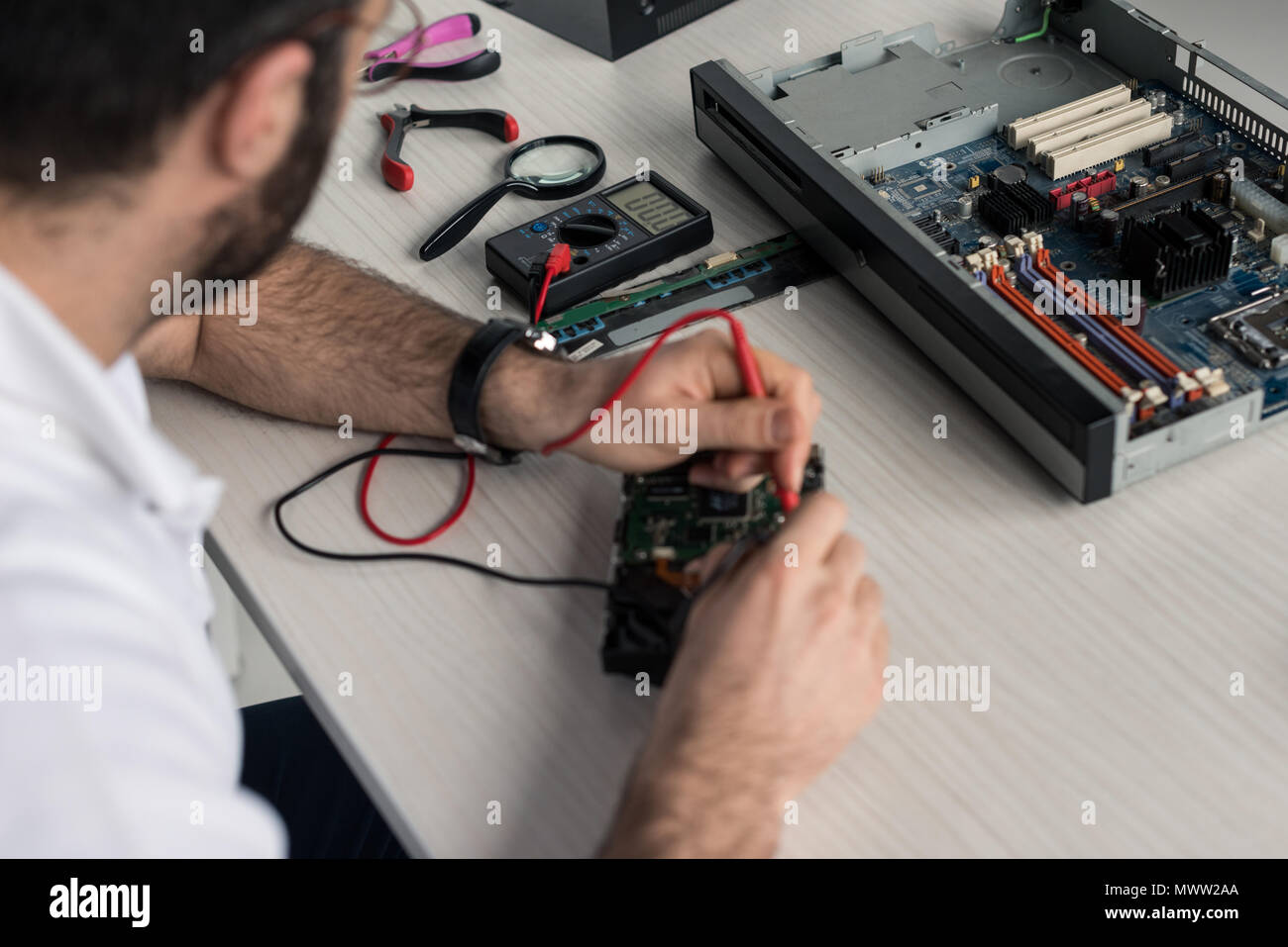 cropped image of man using multimeter while testing hard disk drive Stock Photo