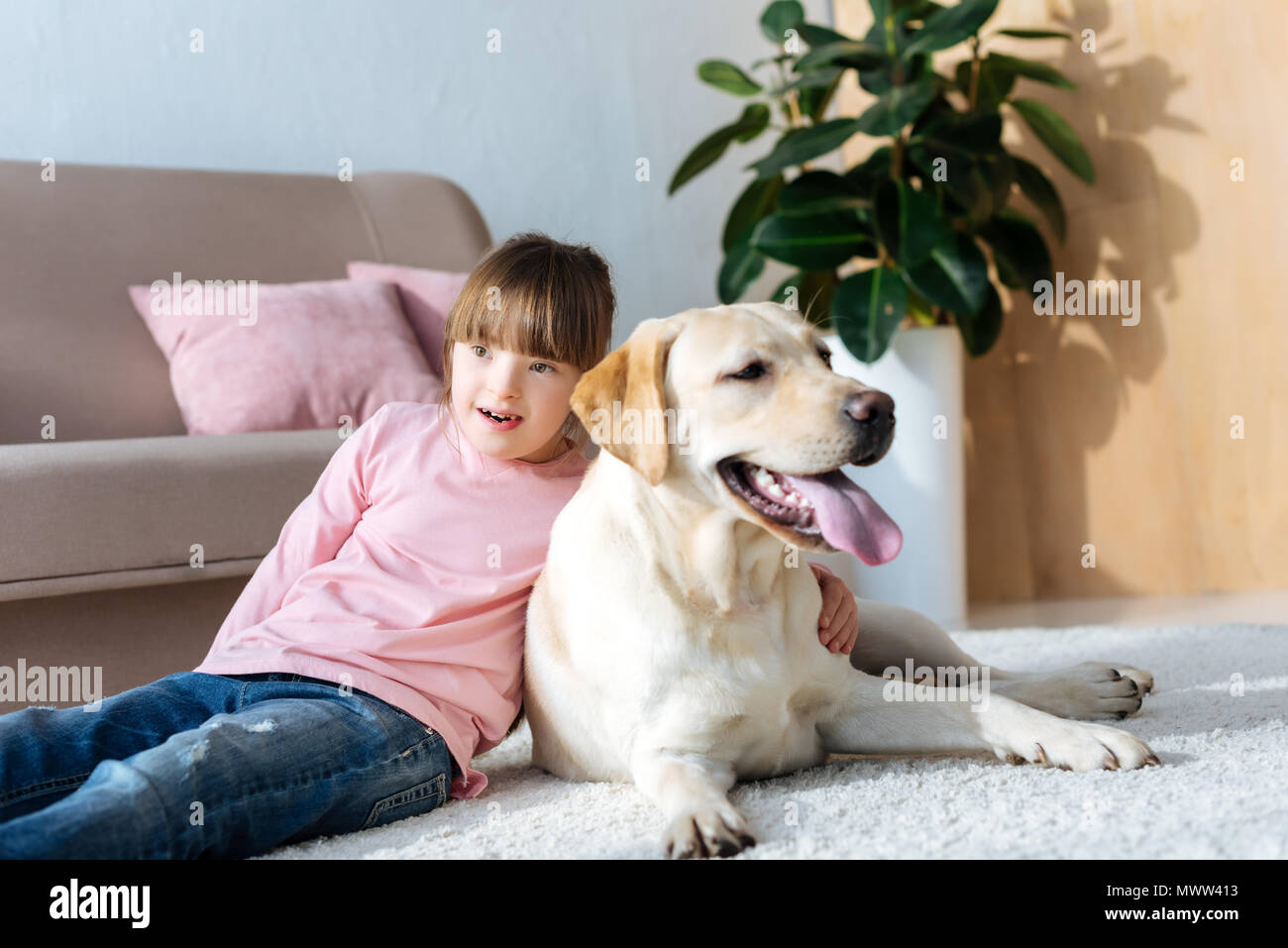 Child with down syndrome hugging Labrador retriever on the floor Stock ...