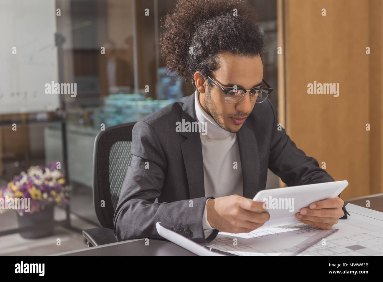 focused young architect using tablet at workplace in modern office Stock Photo
