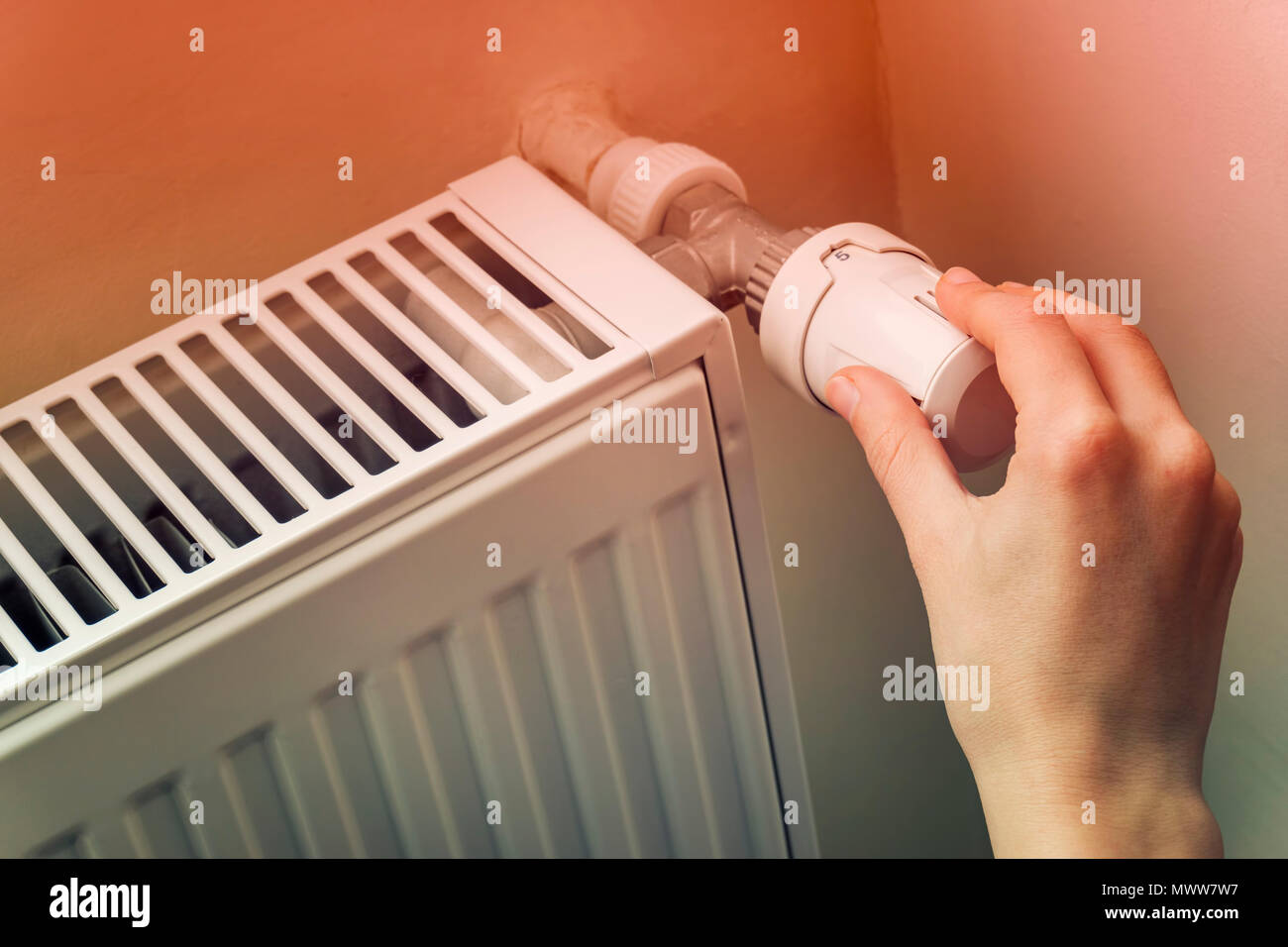 Hand Adjusting The Knob Of Heating Radiator Stock Photo