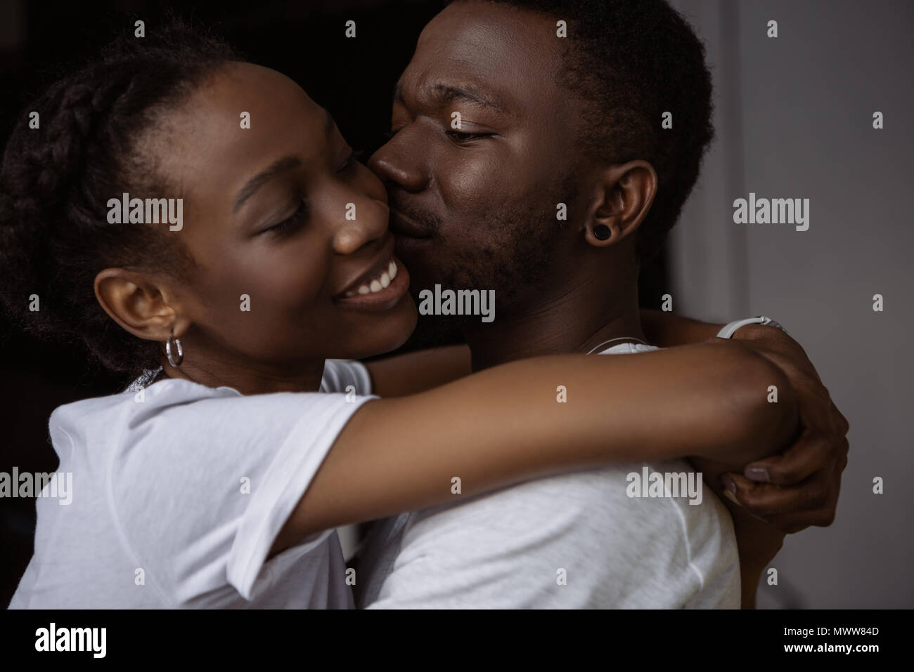 beautiful happy african american couple hugging and kissing at home ...
