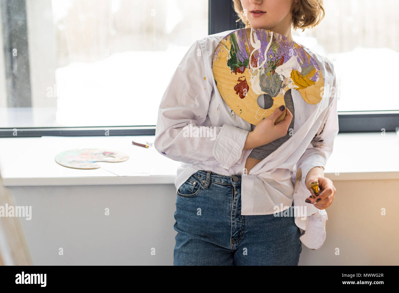 Young inspired girl holding palette in light studio Stock Photo - Alamy