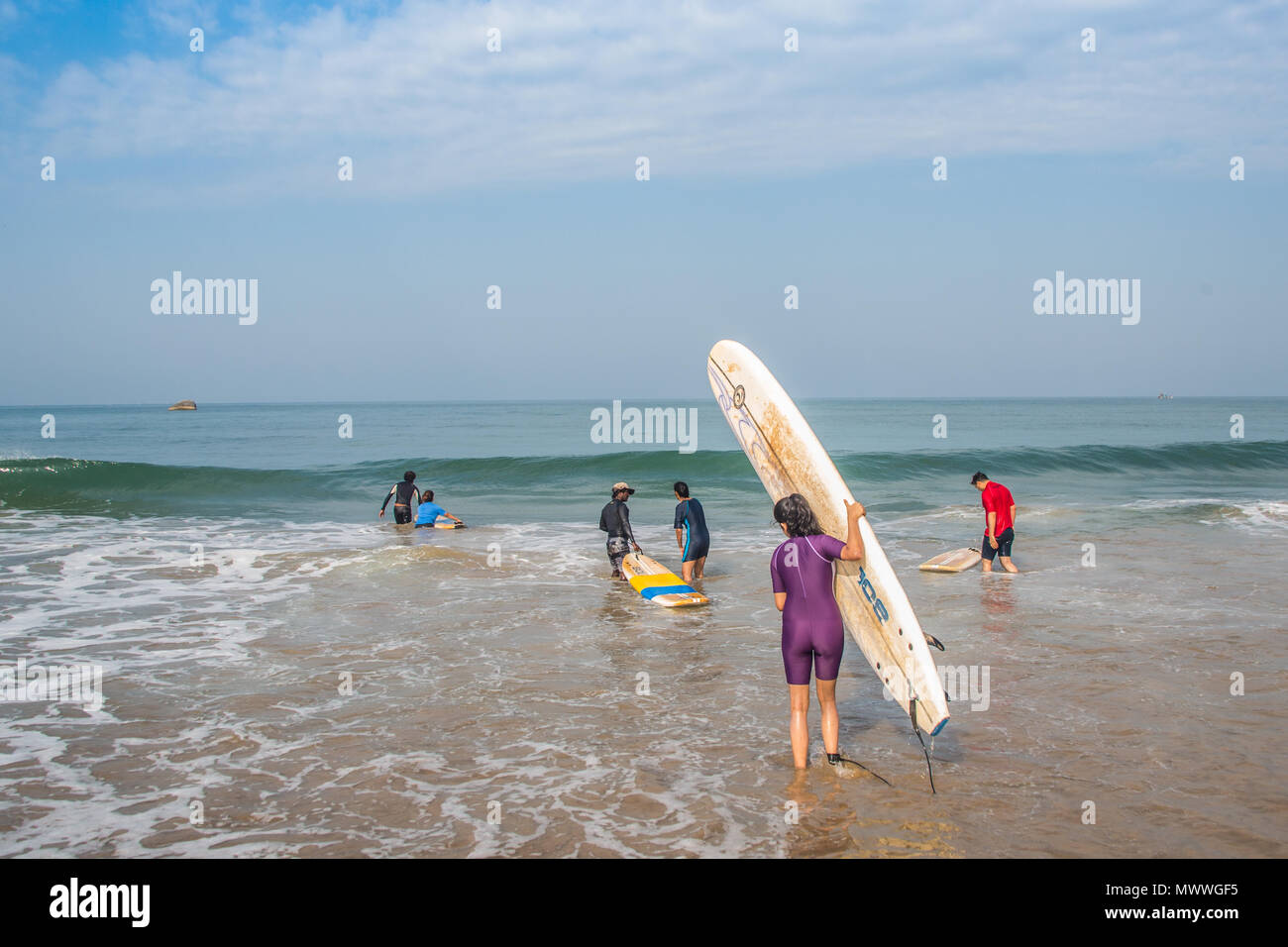 Surf students getting in to the water at a beach in Goa, India, during a early summer session. Stock Photo