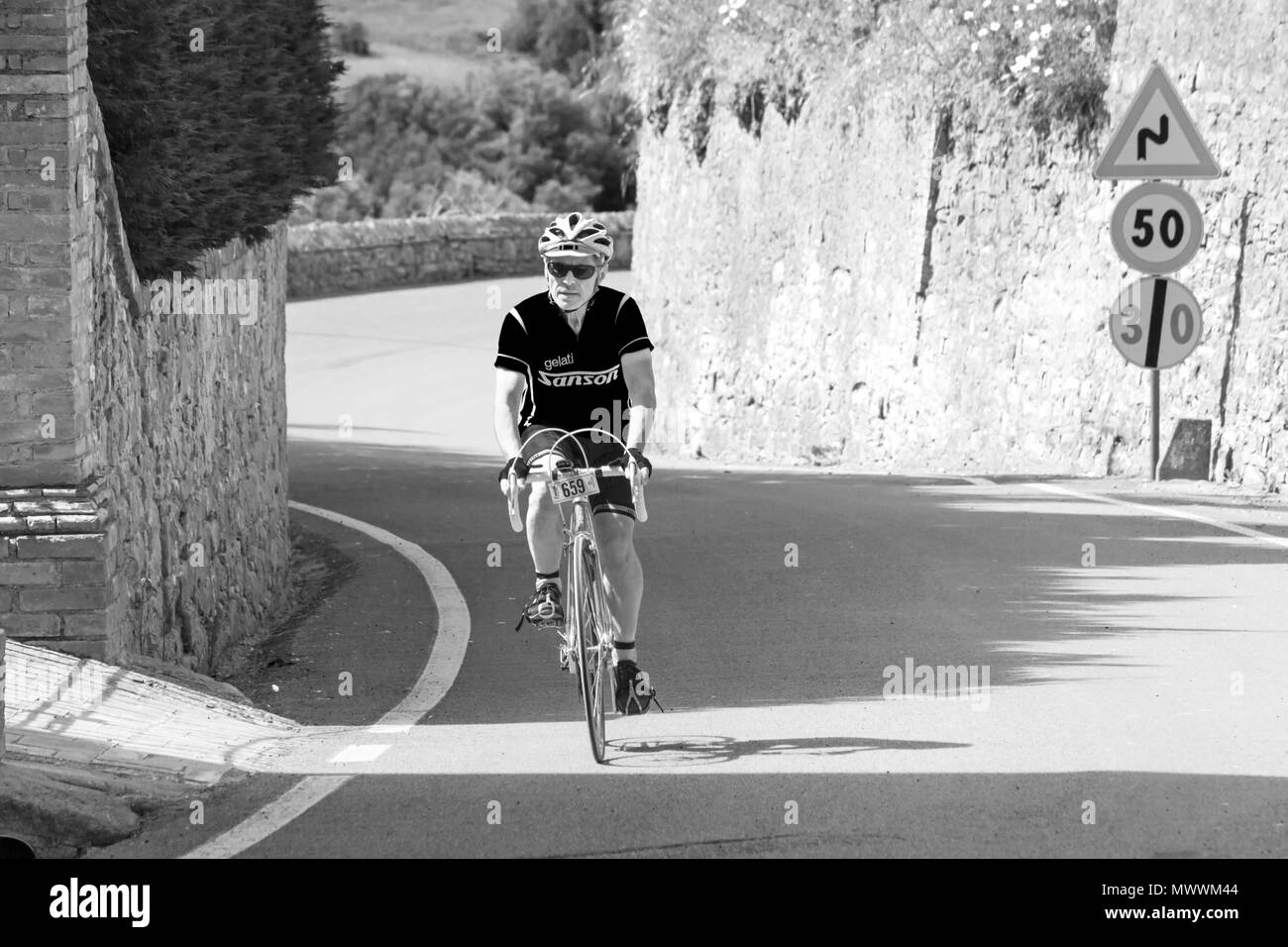 Cyclist riding bike bicycle at Montisi taking part in the Eroica Montalcino, Siena, Tuscany, Italy in May - black and & white monochrome B&W Stock Photo