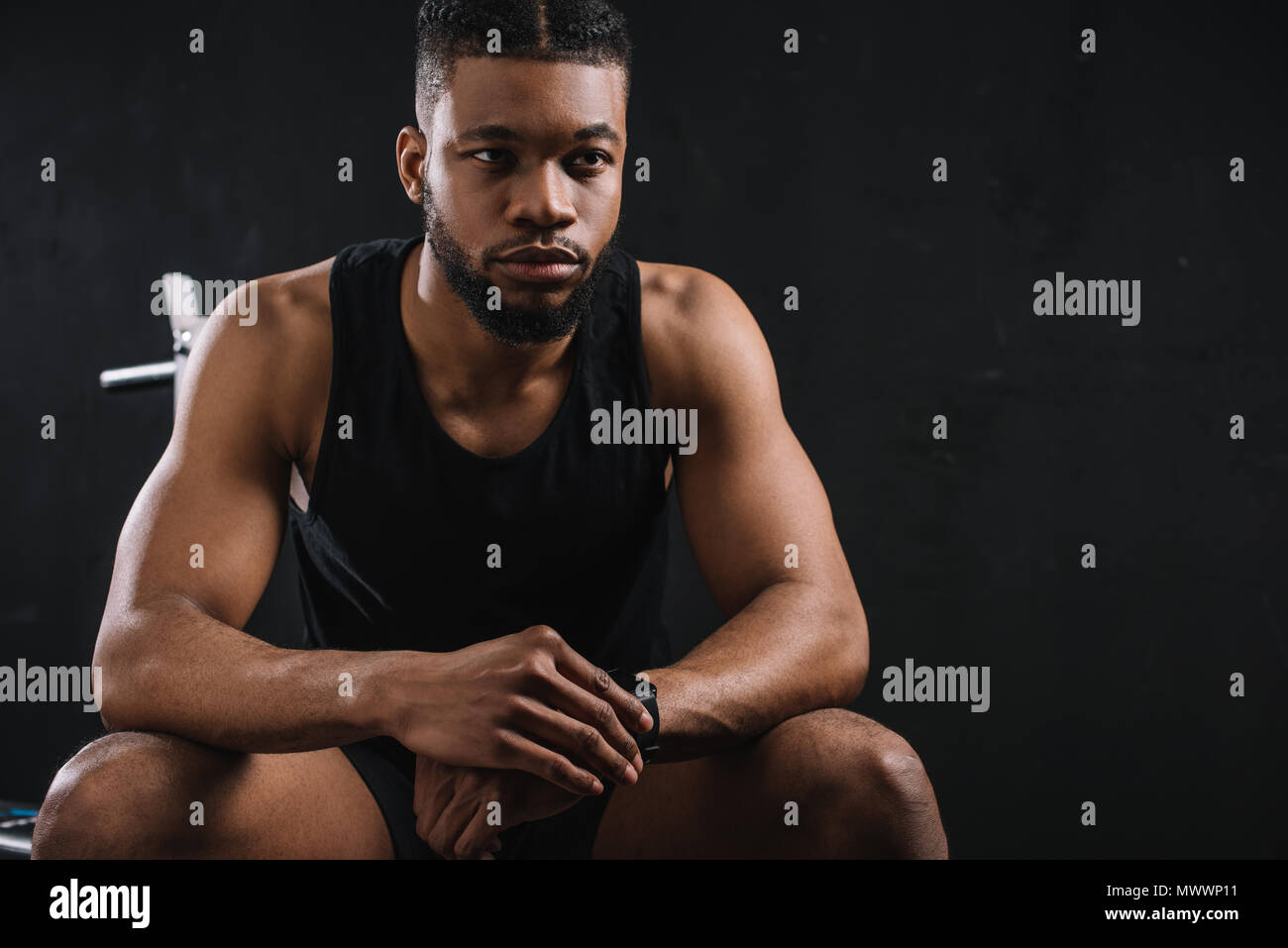handsome young african american sportsman sitting and looking away on ...