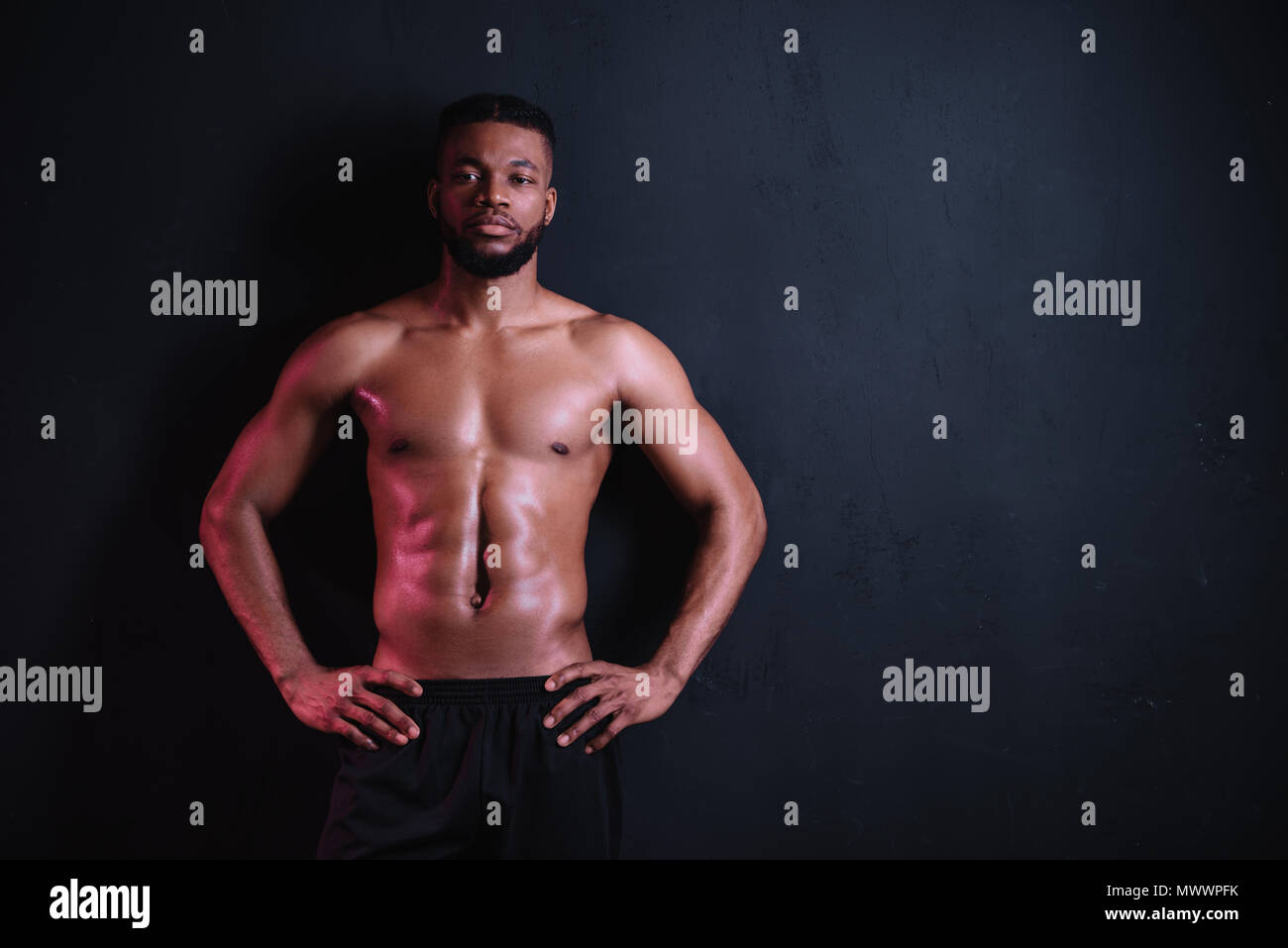 muscular bare-chested african american man standing with hands on