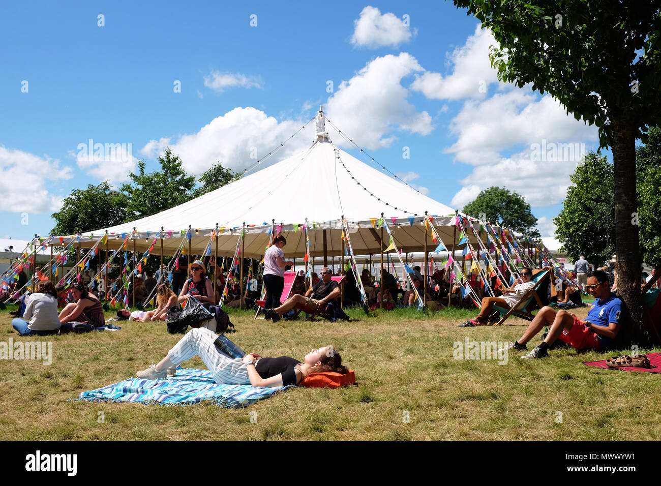 Hay on Wye, UK. 2nd June 2018.- UK Weather - Visitors enjoy the chance to sit and relax in warm sunshine on the Festival lawns between events and sessions with local temperatures of 22c  - The Hay Festival continues to Sunday 3rd June - Photo Steven May / Alamy Live News Stock Photo