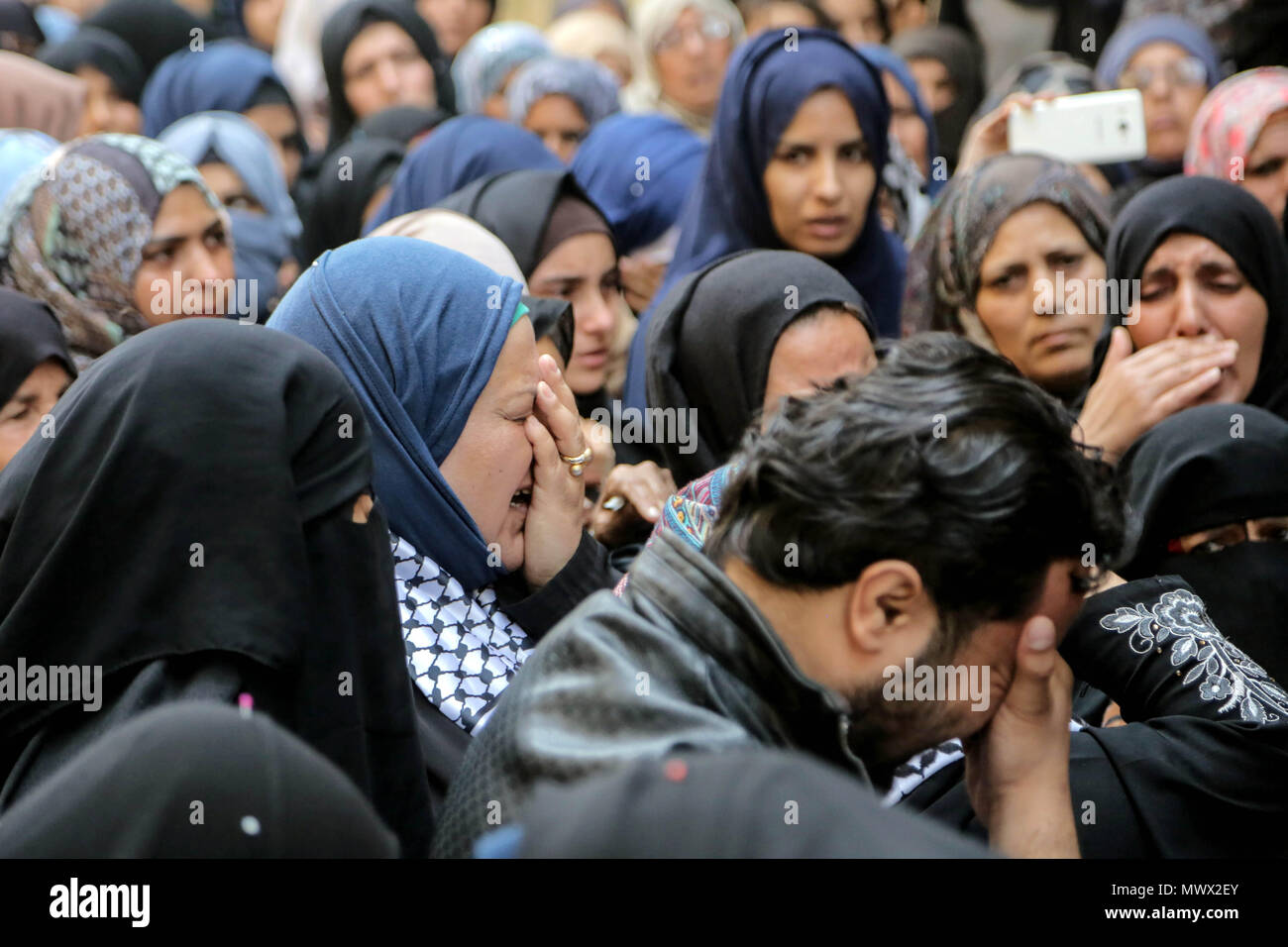 Khan Younis, Gaza Strip, Palestinian Territory. June 2nd 2018.Relatives of Palestinian nurse Razan Al-Najar, 21, mourn during her funeral after she was shot dead by Israeli soldiers, in Khan Younis in the southern Gaza strip on June 2, 2018. Najar, a volunteer medic, was shot by Israeli forces as she ran toward the fortified border fence, east of the south Gaza city of Khan Younis, in a bid to reach a casualty, a witness said. (Credit Image: © Mohamed Zar Credit: ZUMA Press, Inc./Alamy Live News Stock Photo