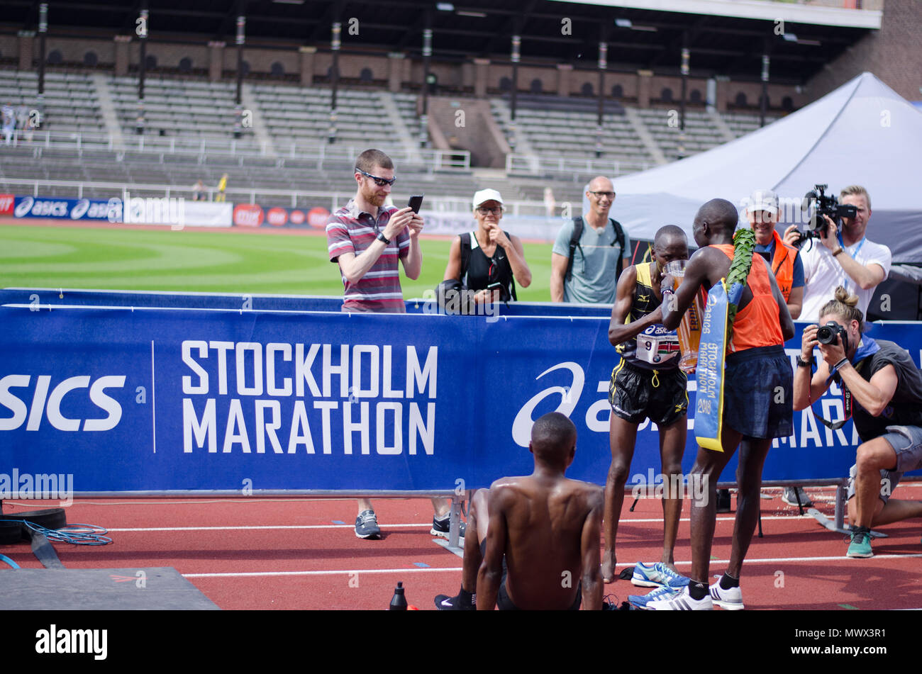 Stockholm, Sweden. 2nd June 2018. The winner of the 40th Stockholm  marathon, Lawi Kiptui from Kenya, gives the runner-up, Dominic Kimwetich  Kangor also from Kenya a sip of the beer the winner