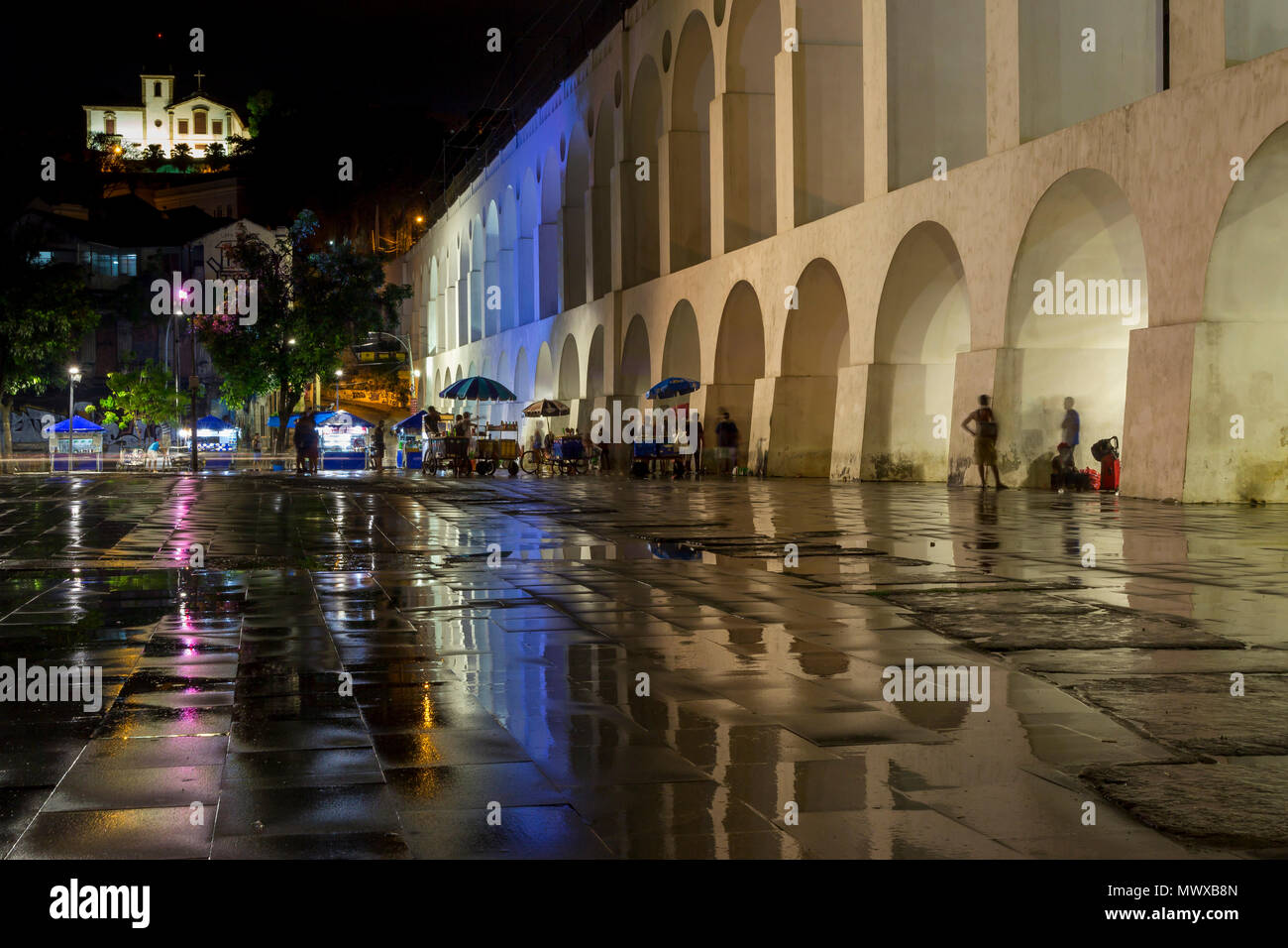 Night shot of the Lapa Arches and the Santa Teresa Convent with reflections on the wet ground shortly after rainfall, Rio de Janeiro, Brazil Stock Photo